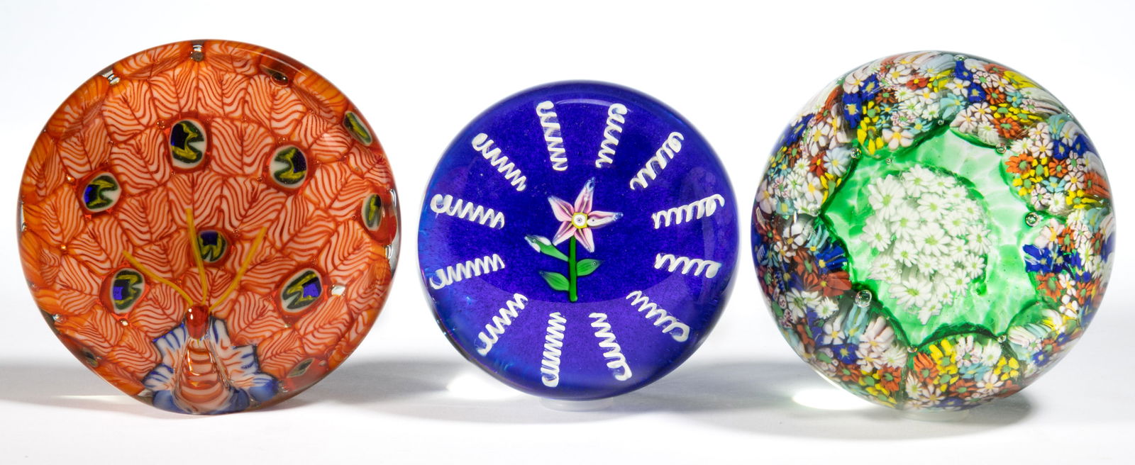 ASSORTED GLASS PAPERWEIGHTS, LOT OF THREE: ASSORTED GLASS PAPERWEIGHTS, LOT OF THREE, comprising an unidentified example featuring a central pink five-petal flower encircled by spaced opal twists, a Murano concentric pattern with central white