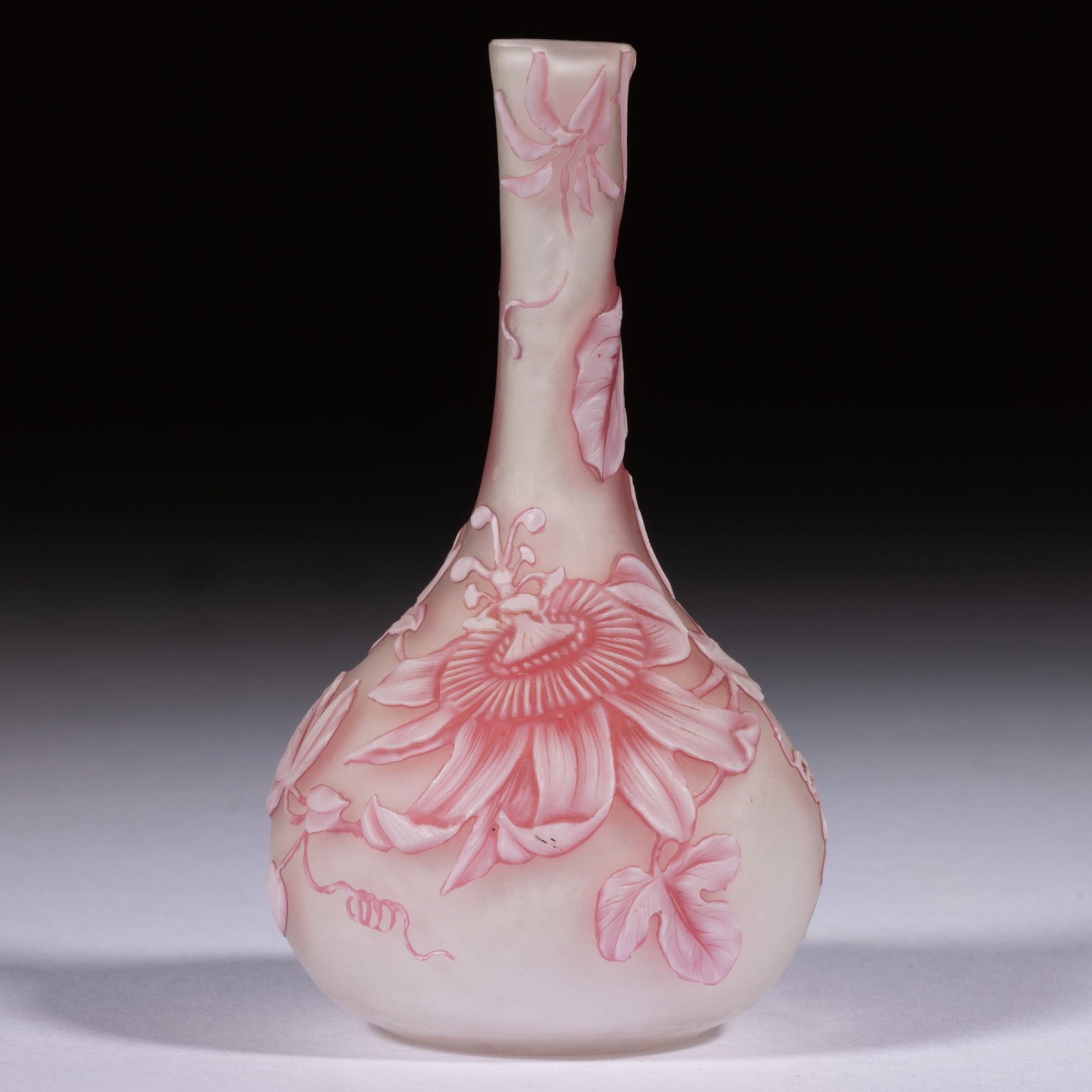 ENGLISH TRI-COLOR CAMEO ART GLASS MINIATURE BUD VASE: ENGLISH TRI-COLOR CAMEO ART GLASS MINIATURE BUD VASE, white to cranberry to colorless, large passion flowers with scrolling vines with many leaves, factory-polished base. Probably Thomas Webb & So