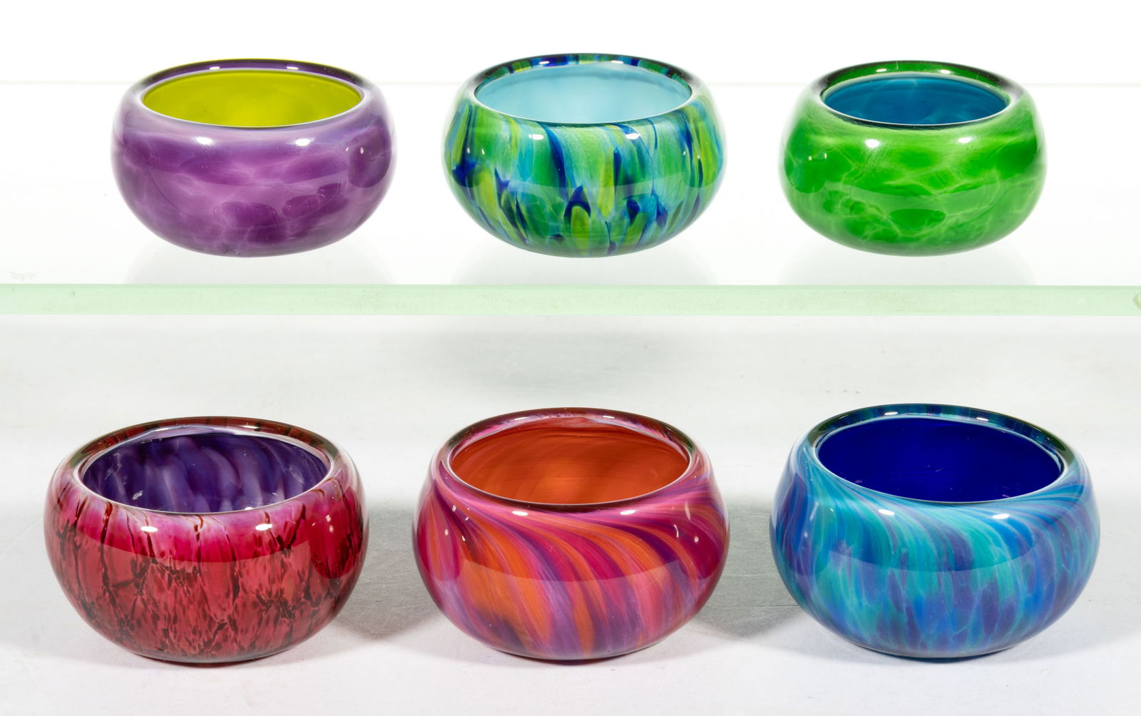 DAVID SMITH MOTTLED STUDIO ART GLASS OPEN SALTS, LOT OF SIX: DAVID SMITH MOTTLED STUDIO ART GLASS OPEN SALTS, LOT OF SIX, various colors, various colored mottled exteriors and interiors, each signed to the underside. Seattle, WA. 20th or 21st century. 1" a