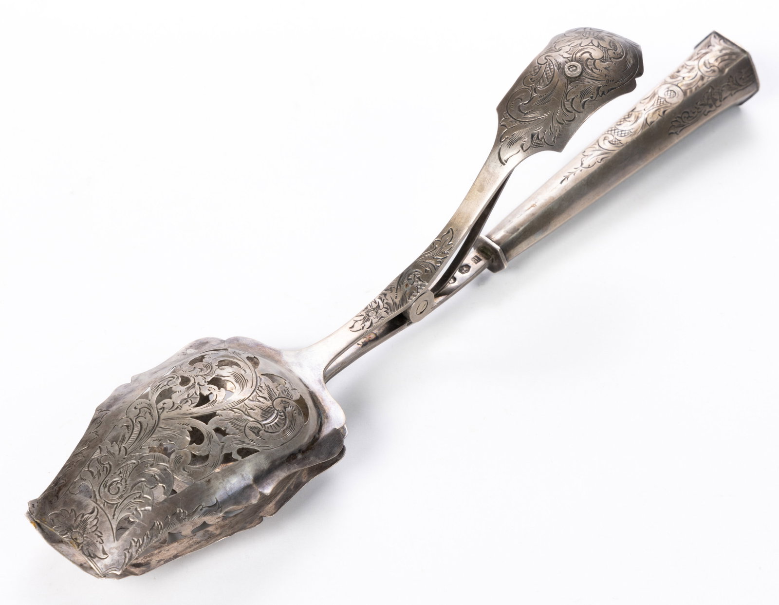 DUTCH ENGRAVED-DECORATED 0.833 SILVER SERVING TONGS: DUTCH ENGRAVED-DECORATED 0.833 SILVER SERVING TONGS, featuring engraved foliate decoration, having two pierced bowls with shaped edges, one straight stem attached to a hollow hexagonal 