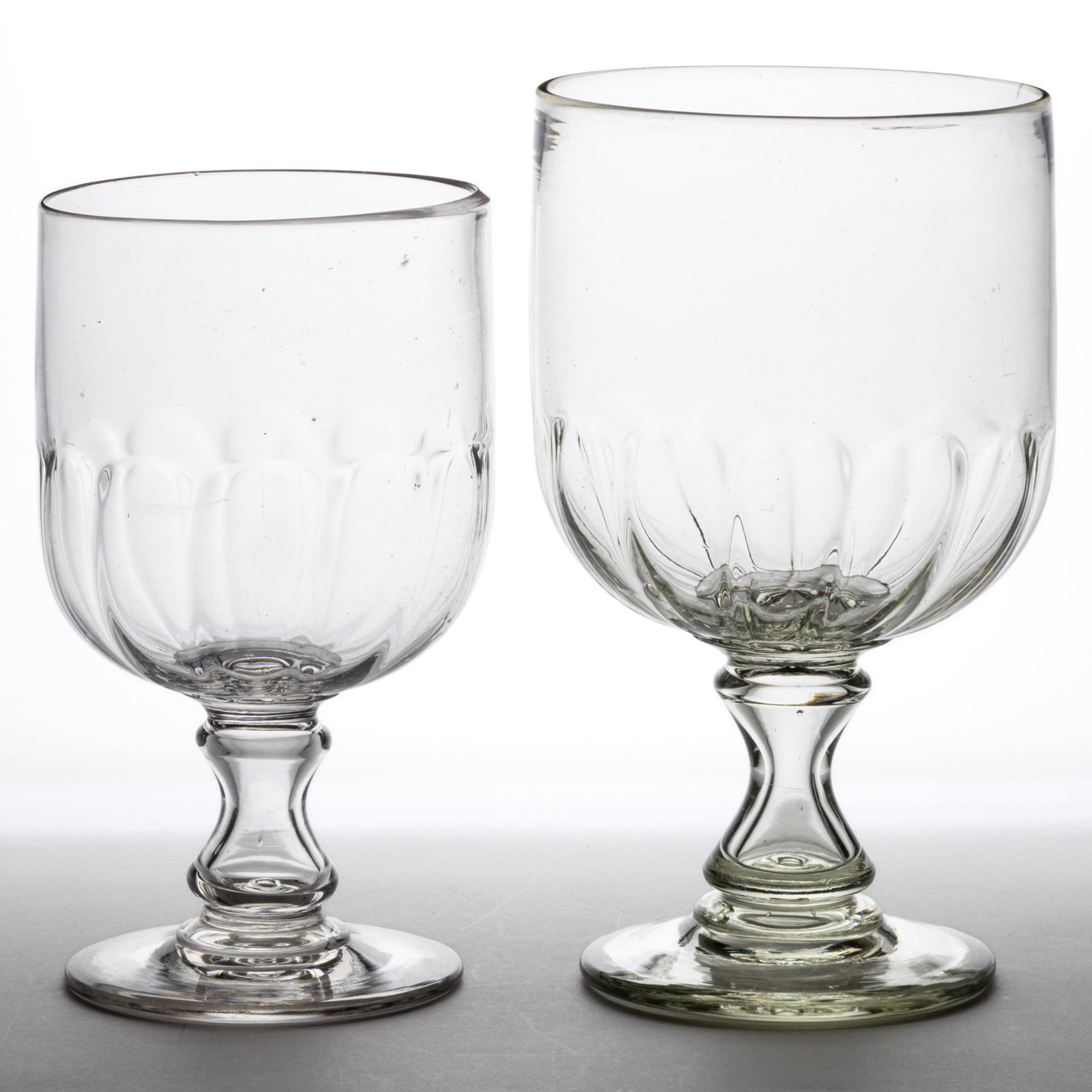 PATTERN-MOLDED APOTHECARY JARS, LOT OF TWO: PATTERN-MOLDED APOTHECARY JARS, LOT OF TWO, colorless, each having a cylindrical bowl with pattern-molded basal flutes, each raised on a hollow waisted stem and applied circular foot, polished pontil 