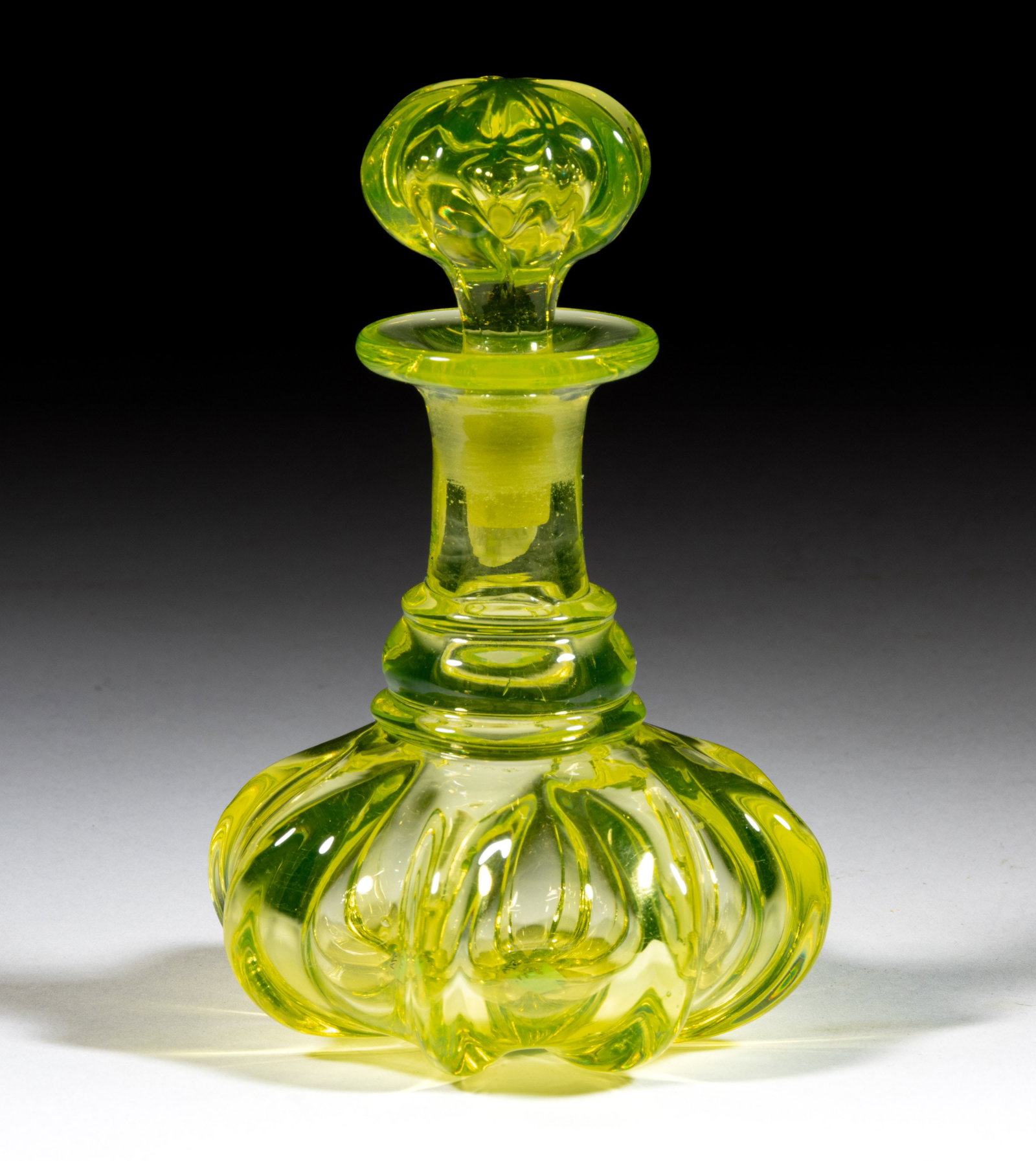 PILLAR-MOLDED COLOGNE BOTTLE: PILLAR-MOLDED COLOGNE BOTTLE, bright canary (reacts to black light), squat form with eight pronounced ribs, with lower applied convex ring, and a plain flanged mouth, polished pontil mark, origin