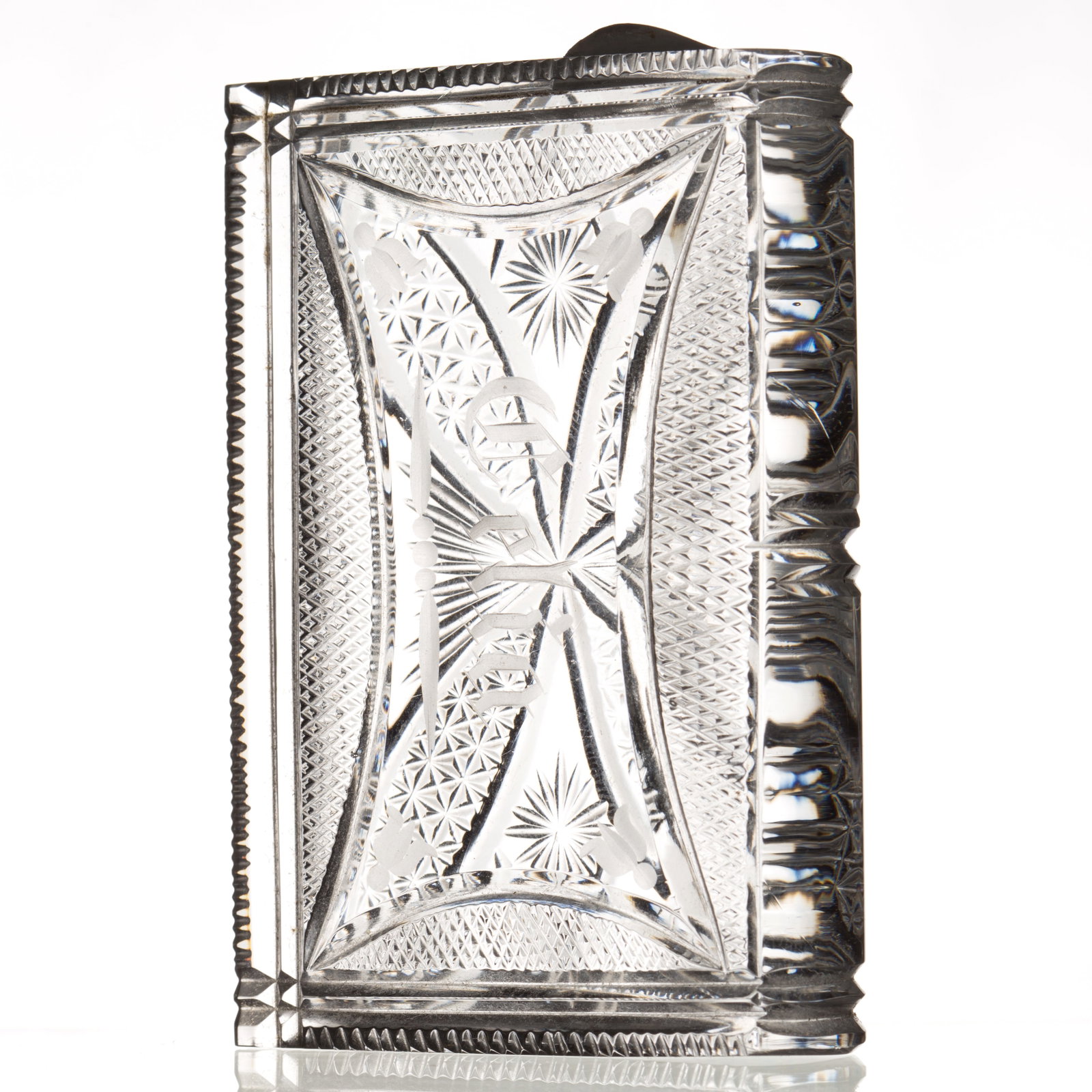 SANDWICH CUT GLASS BOOK-FORM PAPERWEIGHT: SANDWICH CUT GLASS BOOK-FORM PAPERWEIGHT, colorless, front cover with vesicas, stars and fans, back cover with a tiny diamond point bordered reserve engraved "Celia" in the center, serrated 