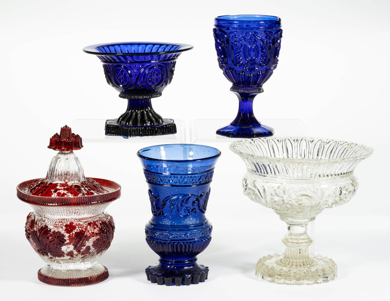 EUROPEAN BLOWN-MOLDED GLASS ARTICLES, LOT OF FIVE: EUROPEAN BLOWN-MOLDED GLASS ARTICLES, LOT OF FIVE, comprising a ruby-stained covered sugar bowl with foliate pattern, a cobalt blue French Lacy goblet and spooner, and two blown-molded footed dishes.