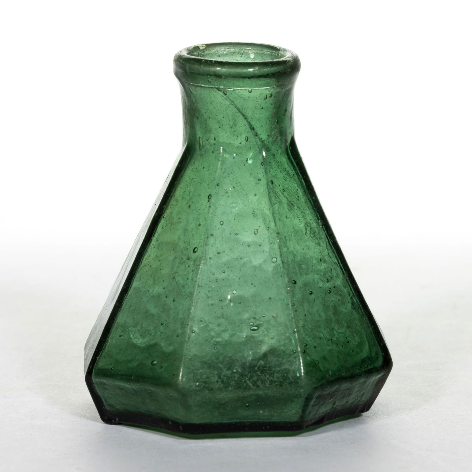 BLOWN-MOLDED GLASS UMBRELLA INK BOTTLE: BLOWN-MOLDED GLASS UMBRELLA INK BOTTLE, mossy green, octagonal conical form with inwardly-rolled mouth and rough pontil mark. Likely Mid-Atlantic origin. Circa 1850. 2 1/8" H, 2" D