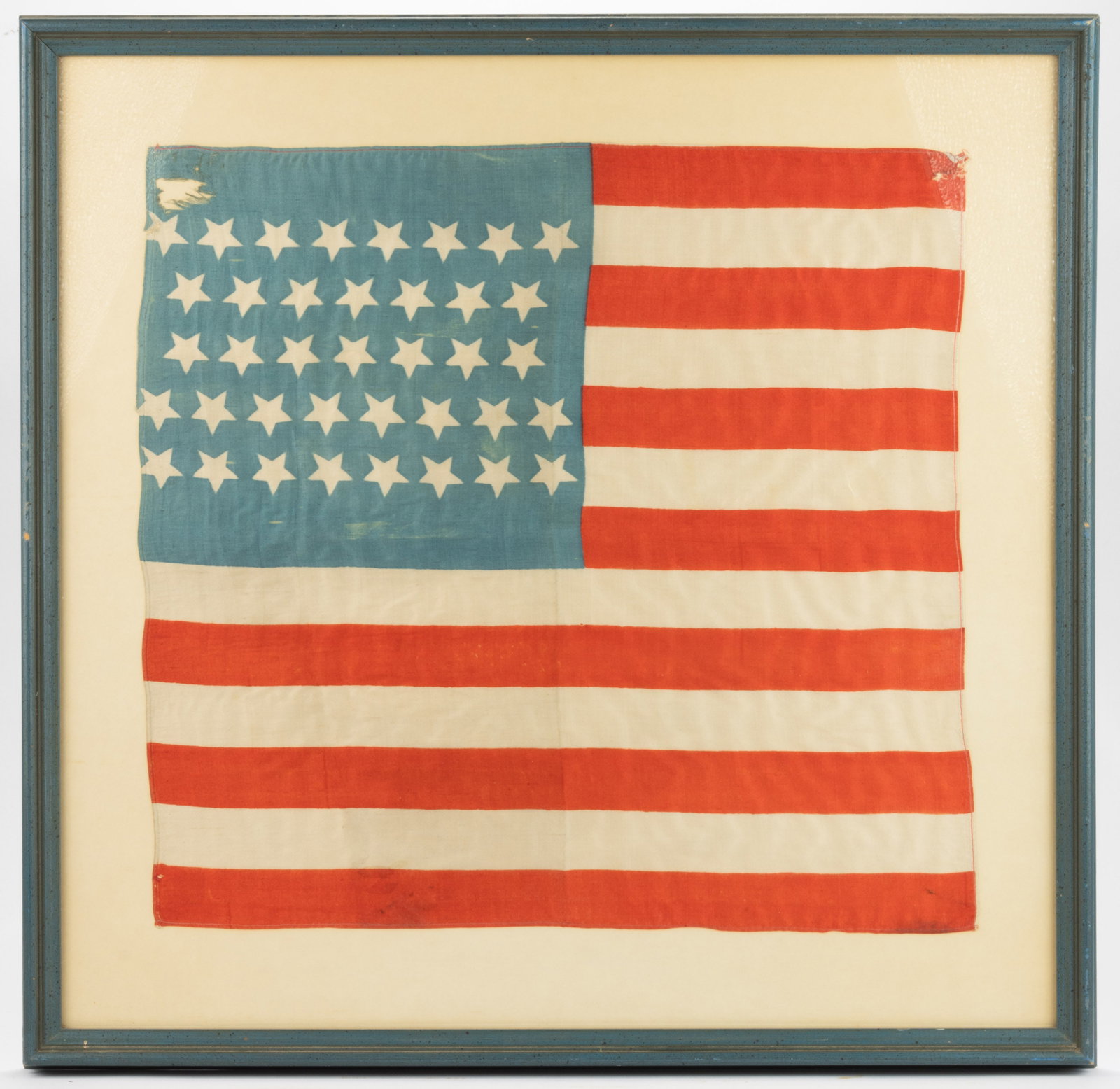 38-STAR AMERICAN NATIONAL COLORADO STATEHOOD PRINTED PARADE FLAG: 38-STAR AMERICAN NATIONAL COLORADO STATEHOOD PRINTED PARADE FLAG, silk, the cornflower blue canton exhibiting unusual 8/7/7/8/8 pattern, wherein the stars are tilted in orientation. Housed under glass