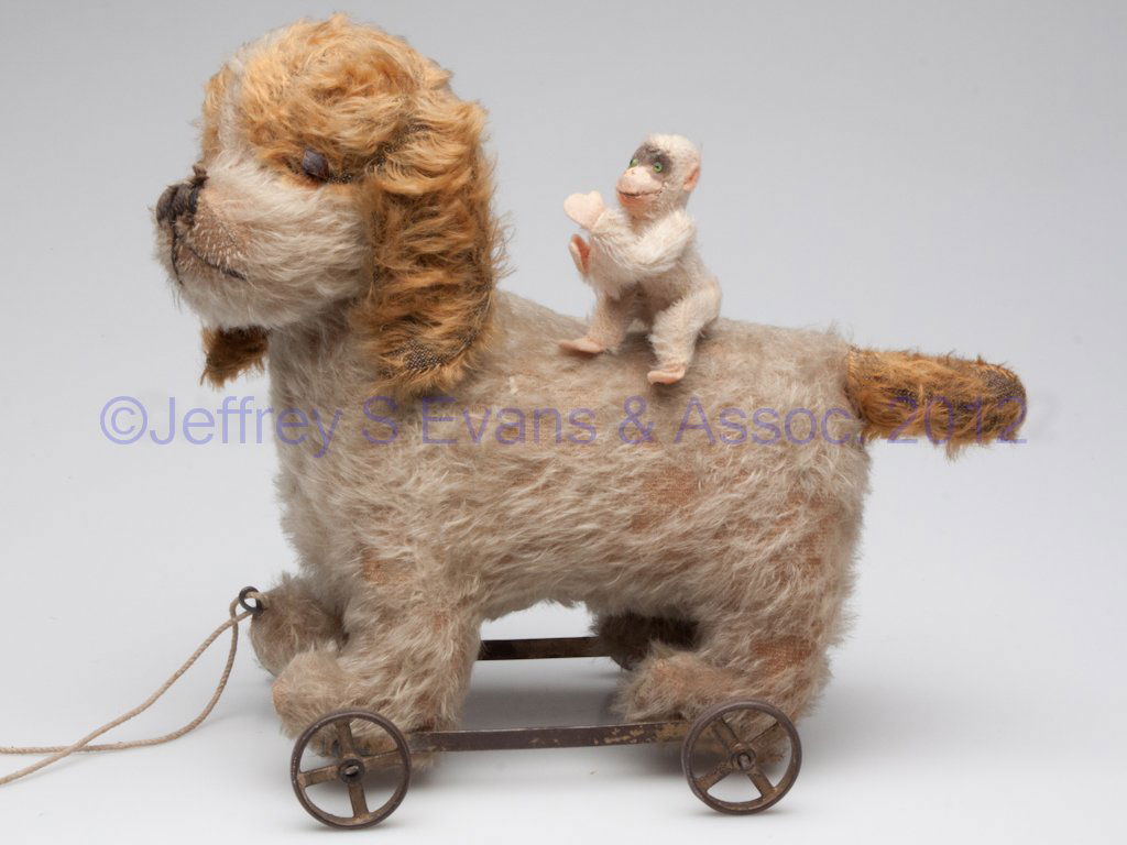 STUFFED ANIMAL TOYS, LOT OF TWO: STUFFED ANIMAL TOYS, LOT OF TWO, comprising a Steiff monkey with button in foot, and an unmarked dog on iron wheels and with swivel head. First half 20th century. 3" and 10 1/2" H. Provenance: From th