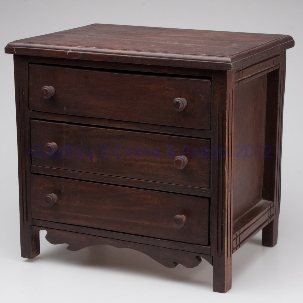 PRIMITIVE MIXED WOOD DOLL CHEST OF DRAWERS: PRIMITIVE MIXED WOOD DOLL CHEST OF DRAWERS, molded top above three drawers, made from shipping crates and other wood. 20th century. 13 1/2" H, 14 1/2" x 10 1/2".