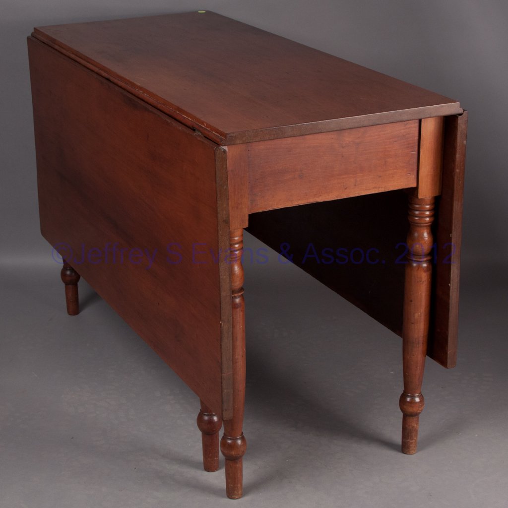 AMERICAN SHERATON CHERRY FALL-LEAF TABLE: AMERICAN SHERATON CHERRY FALL-LEAF TABLE, rectangular top and two hinged leaves raised on six turned legs, two of which swivel to support the leaves. Mid 19th century. 29 1/2" H, 44" x 20" closed, 60"