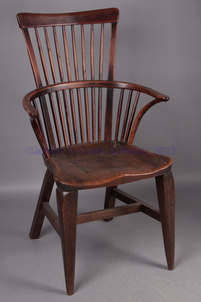 BRITISH WINDSOR ARMCHAIR: BRITISH WINDSOR ARMCHAIR, mixed woods, comb-back above a shaped saddle seat and square legs. 19th century. 40" HOA, 19" H seat. Literature: Parallels Thuro II, p. 117q. Provenance: The collection of S