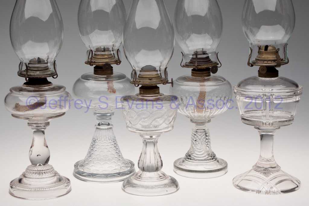 ASSORTED GLASS KEROSENE STAND LAMPS, LOT OF FIVE: ASSORTED GLASS KEROSENE STAND LAMPS, LOT OF FIVE, colorless, including Duncan #90/Zippered Block, Rope Band, Stippled Fishscale and Rib, each with burner. Fourth quarter 19th/first quarter 20th centur