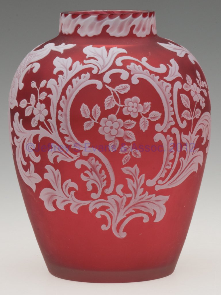 ENGLISH CARVED CAMEO GLASS VASE: ENGLISH CARVED CAMEO GLASS VASE, white over ruby with acid finish, floral and cartouche decorations, polished rim, pontil mark and table ring. Fourth quarter 19th century. 5 3/4" H.
