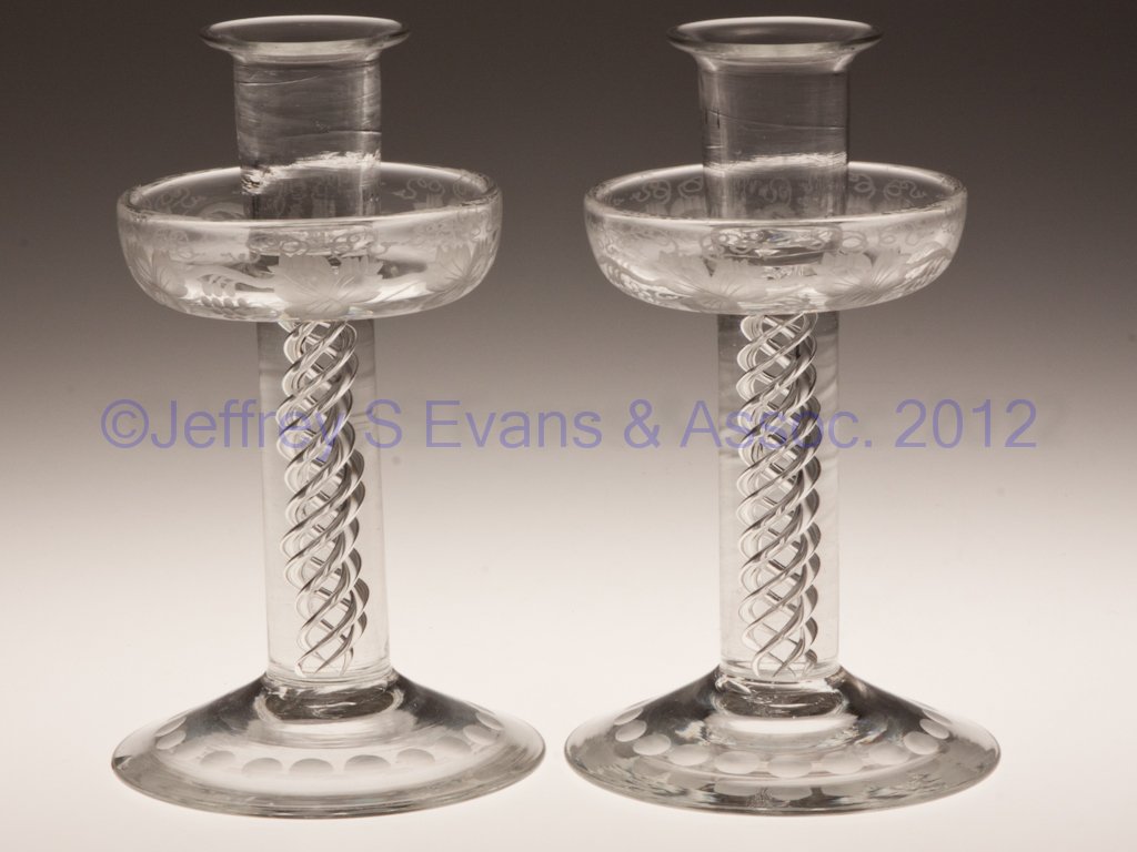 PAIR OF AIR-TWIST STEM CANDLESTICKS: PAIR OF AIR-TWIST STEM CANDLESTICKS, colorless, engraved Vintage grape design around drip pans, each with a rough pontil mark. 20th century. 6 3/4" H.
