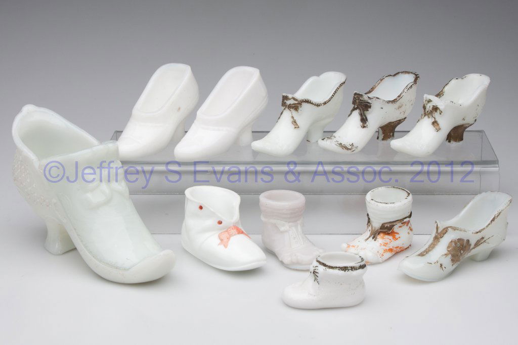 ASSORTED MILK GLASS FIGURAL SHOES / BOOTS, LOT OF: ASSORTED MILK GLASS FIGURAL SHOES / BOOTS, LOT OF 11, opaque white, some with decoration, including a large covered dish and two match holders. First half 20th century. 1 1/2" to 5" HOA. Provenance: F