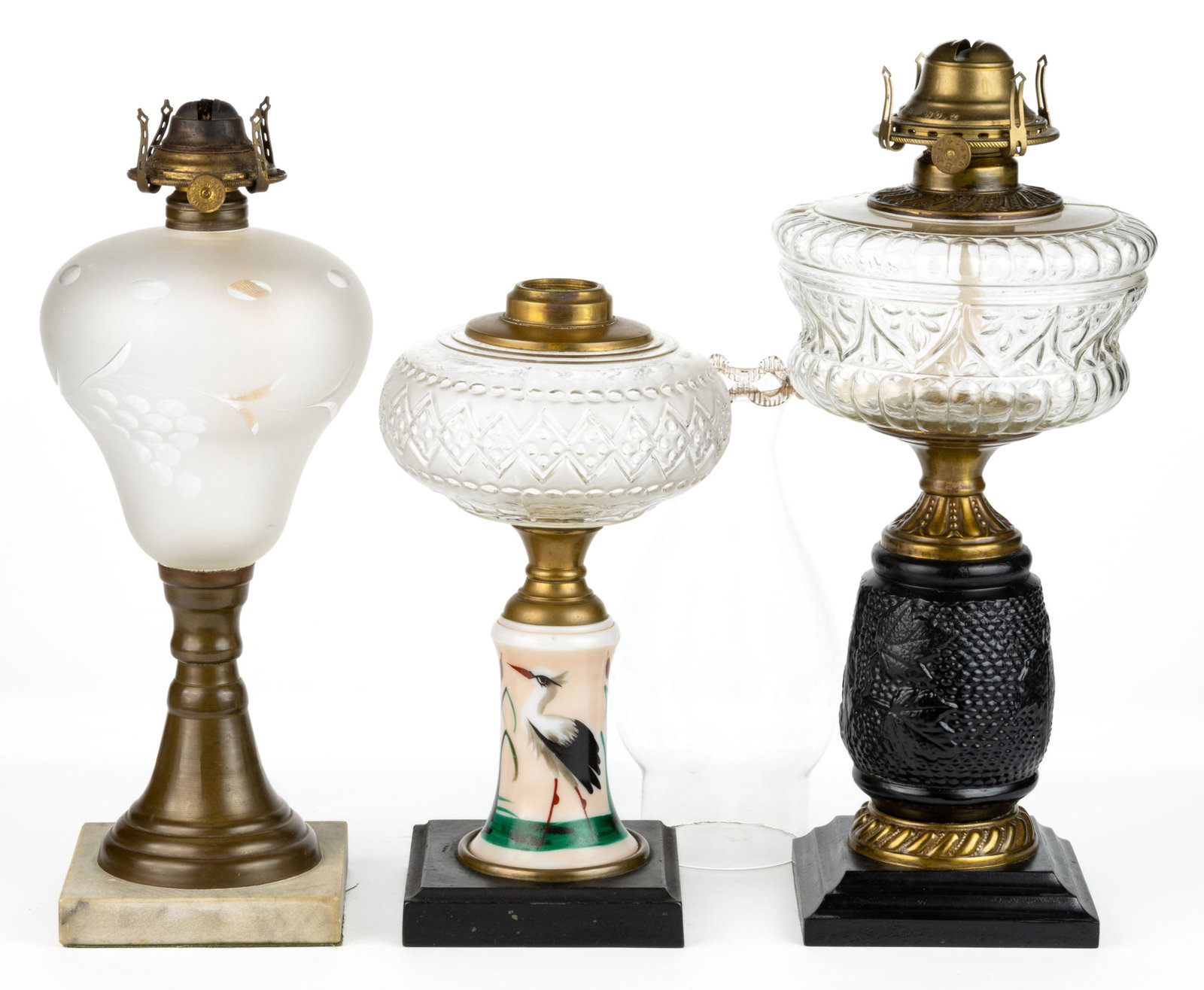 ASSORTED PATTERN COMPOSITE STAND LAMPS, LOT OF TWO: ASSORTED PATTERN COMPOSITE STAND LAMPS, LOT OF TWO, each with a colorless embossed font, comprising an example with diamond band pattern and an opaque white with pink shading and heron painted decorat