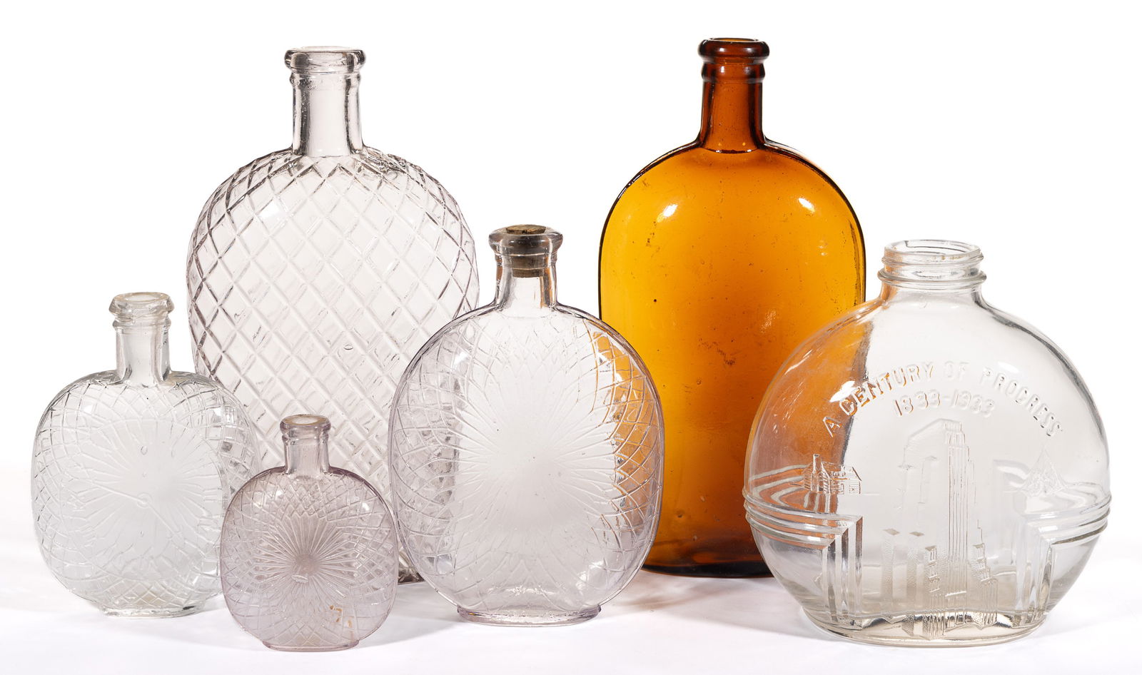 ASSORTED BOTTLES / FLASKS, LOT OF SIX: ASSORTED BOTTLES / FLASKS, LOT OF SIX, including quilted examples, pumpkin-seed, strap sided, and a Chicago World's Fair jar. 19th and 20th centuries. Tallest 9 1/4" HOA. Provenance: From a