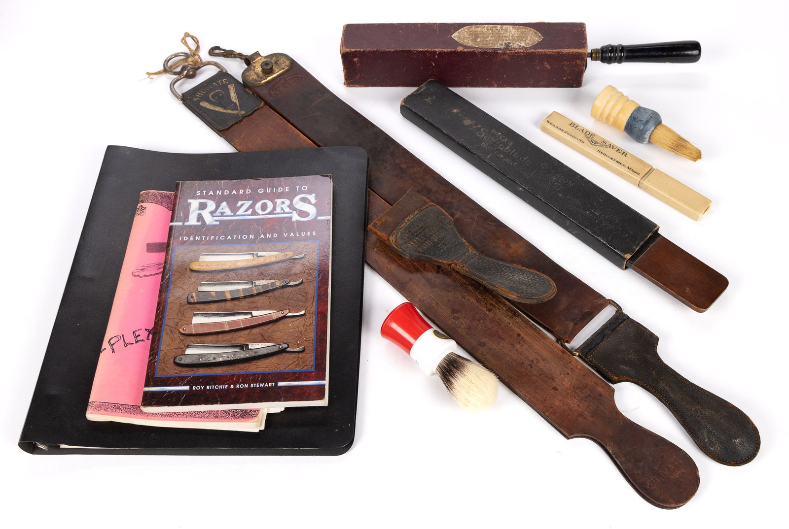 RAZOR / SHAVING ACCESSORIES AND REFERENCE VOLUMES, UNCOUNTED LOT: RAZOR / SHAVING ACCESSORIES AND REFERENCE VOLUMES, UNCOUNTED LOT, including two razor strops, one leather handle of a strop, a Blade Saver, two brushes, two references volumes, and a binder full of ra