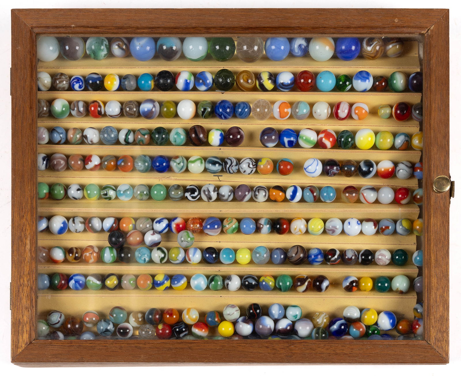 ASSORTED GLASS MACHINE-MADE MARBLES IN DISPLAY CASE, UNCOUNTED LOT: ASSORTED GLASS MACHINE-MADE MARBLES IN DISPLAY CASE, UNCOUNTED LOT, various colors and various makers, many color combinations. Various makers. 20th century. Various sizes. Provenance: Collection of