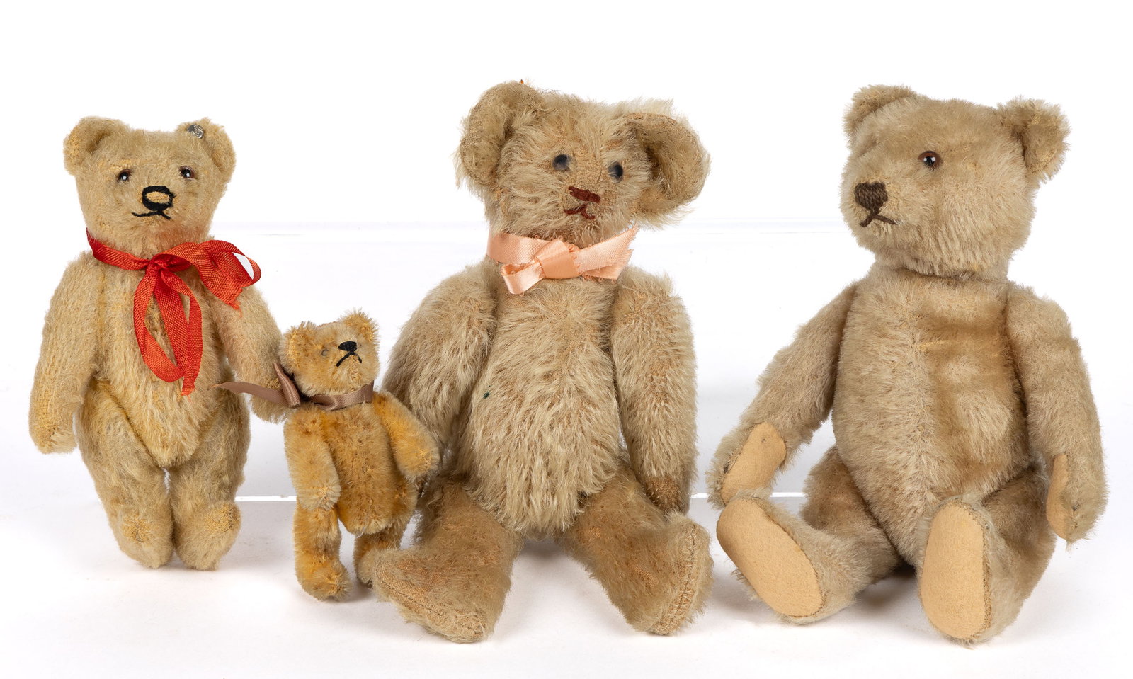 STEIFF AND OTHER STUFFED TEDDY BEARS, LOT OF FOUR: STEIFF AND OTHER STUFFED TEDDY BEARS, LOT OF FOUR, each fully jointed, second-smallest example retaining original metal button and tag in left ear. Mid 20th century. Largest 8 1/2" HOA. Prov