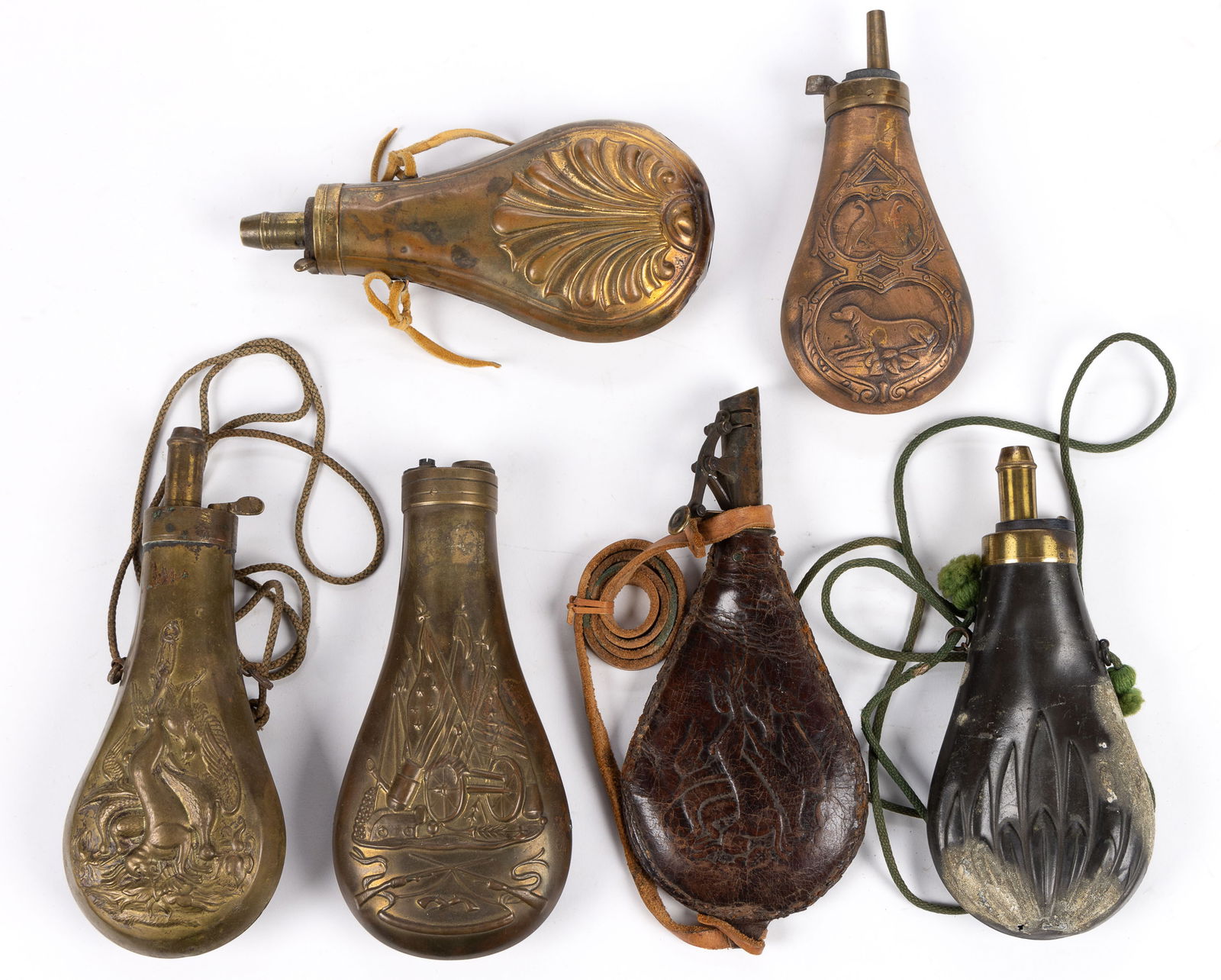 BRASS AND LEATHER POWDER FLASKS, LOT OF SIX: BRASS AND LEATHER POWDER FLASKS, LOT OF SIX, brass, leather, and other metals, all with embossed designs, four with hunt / animal scenes. Continental and possibly American. 19th century. Largest, 8&qu