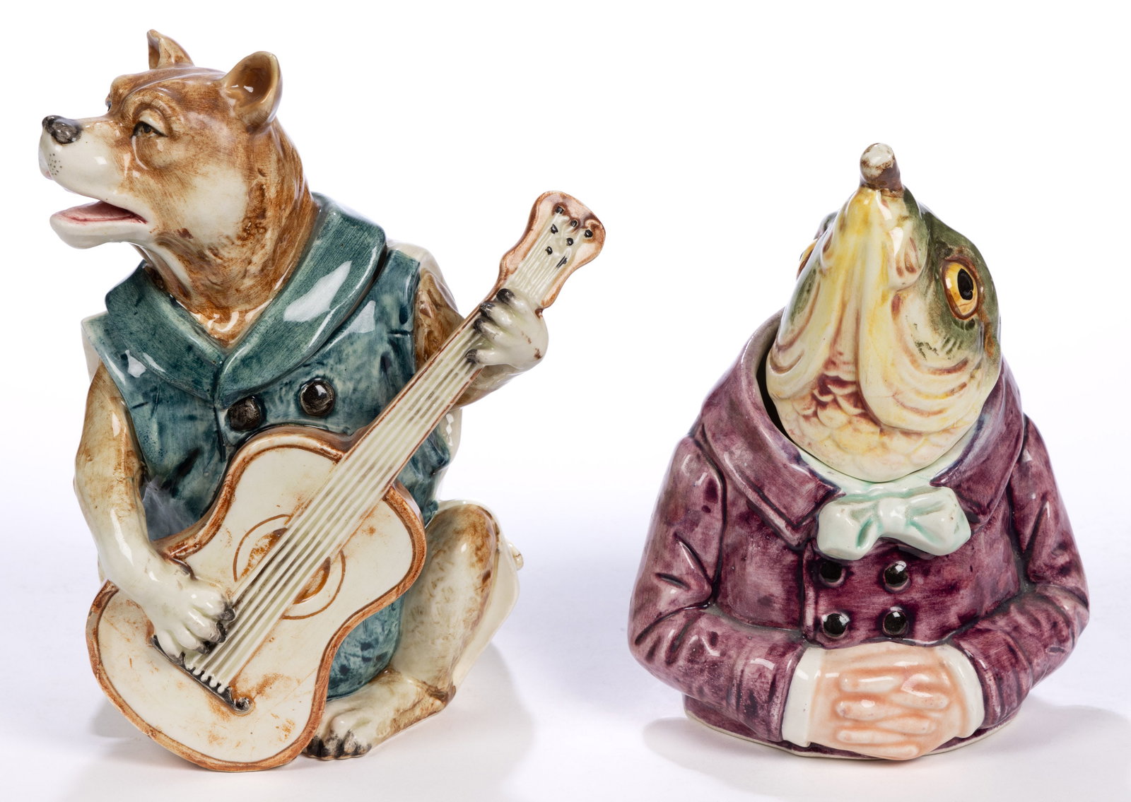 CONTINENTAL MAJOLICA CERAMIC FIGURAL ANTHROPOMORPHIC ANIMAL HUMIDORS, LOT OF TWO: CONTINENTAL MAJOLICA CERAMIC FIGURAL ANTHROPOMORPHIC ANIMAL HUMIDORS, LOT OF TWO, comprising a dog wearing a blue vest and playing the guitar and a fish smoking a cigar and wearing a purple jacket, he