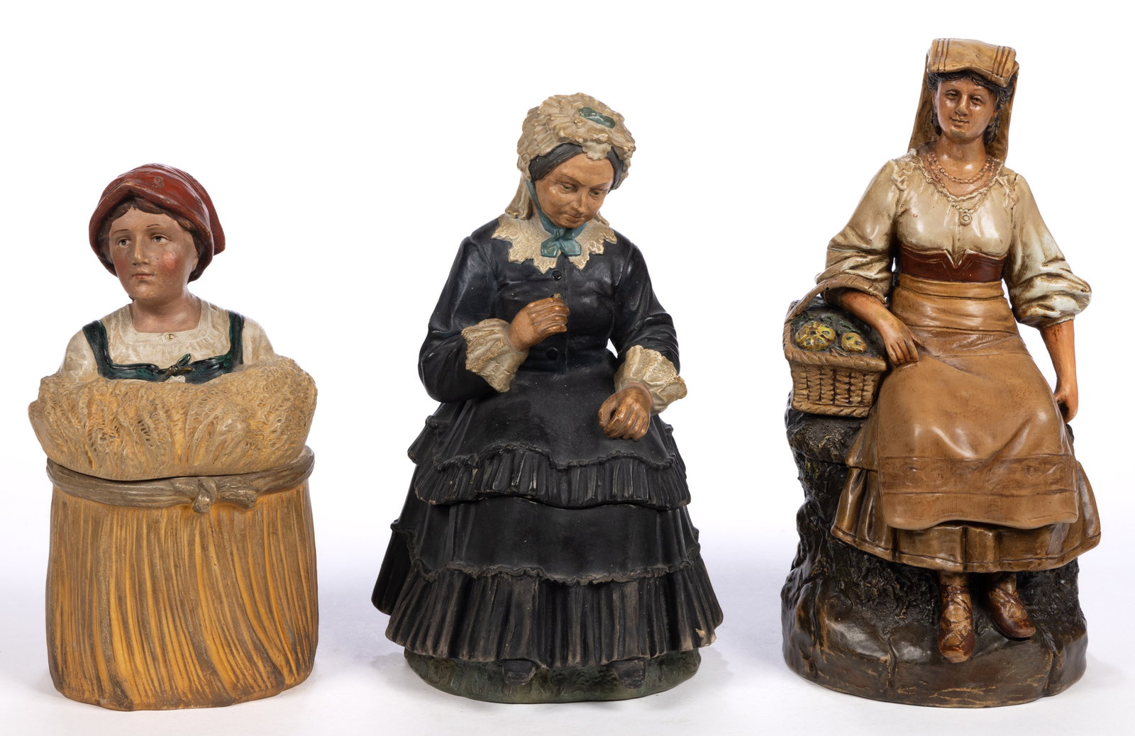 CONTINENTAL CERAMIC WOMAN FIGURAL HUMIDORS, LOT OF THREE: CONTINENTAL CERAMIC WOMAN FIGURAL HUMIDORS, LOT OF THREE, comprising one example depicting a young lady wearing a red scarf and emerging from a sheaf of wheat, one featuring a sitting o