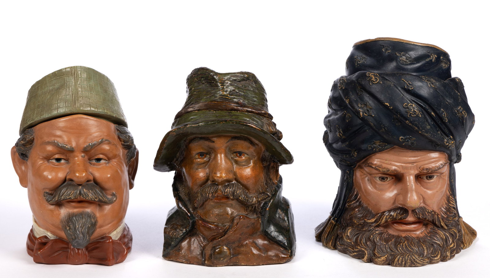 CONTINENTAL CERAMIC FIGURAL HEAD HUMIDORS, LOT OF THREE: CONTINENTAL CERAMIC FIGURAL HEAD HUMIDORS, LOT OF THREE, each having facial hair, comprising a sheikh example wearing a turban, one example with a drooping hat and raised jacket collar, and one e