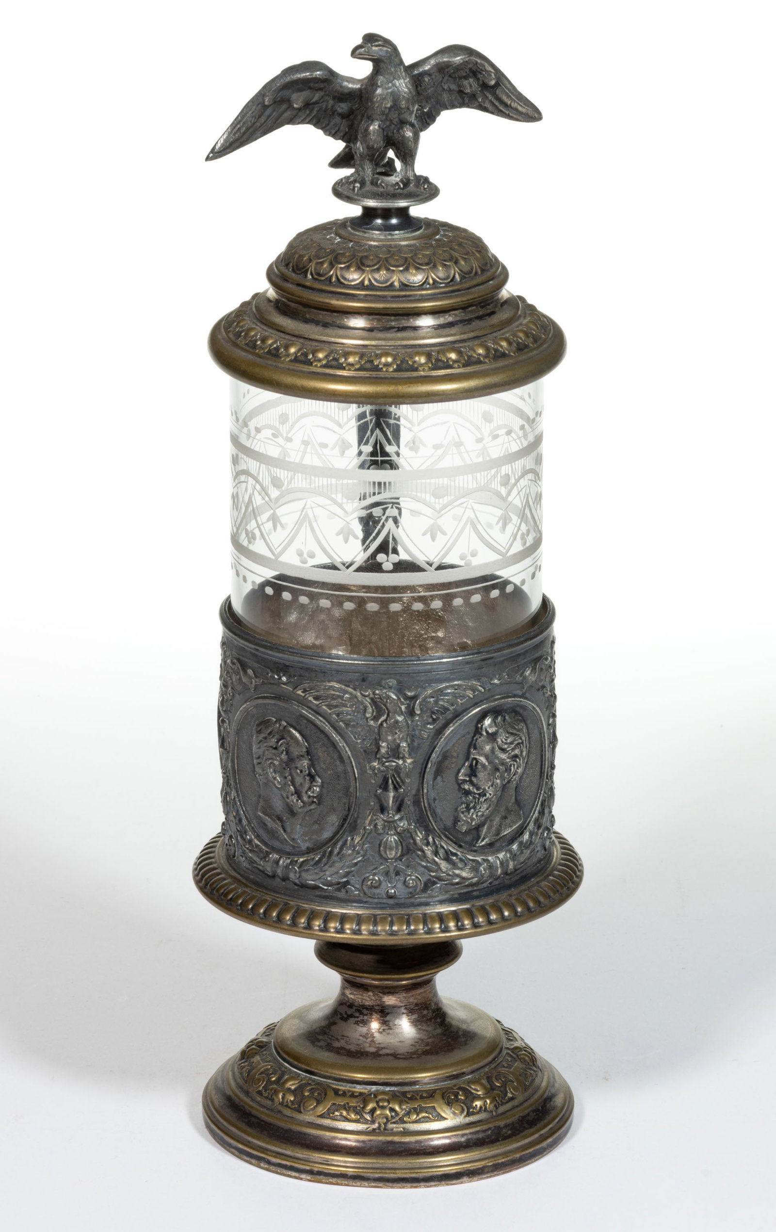 EUROPEAN BLOWN AND ENGRAVED GLASS STEIN: EUROPEAN BLOWN AND ENGRAVED GLASS STEIN, colorless, cylindrical insert with an upper complex band of drapery and tassel decoration, fitted into a silver-plated frame and mount featuring the side 