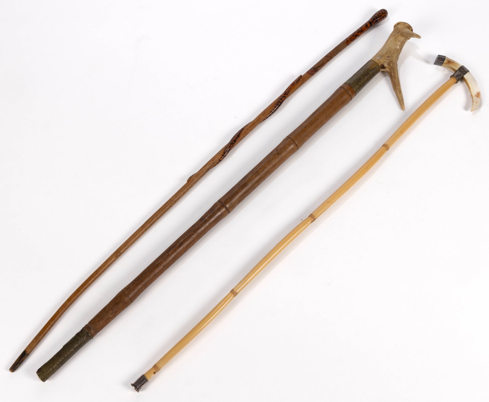 ANTIQUE CANES / WALKING STICKS, LOT OF THREE: ANTIQUE CANES / WALKING STICKS, LOT OF THREE, comprising a bamboo-turned ash/oak shaft set with an antler handle carved "AG / 1880" to the top, above a wide brass band engraved &qu