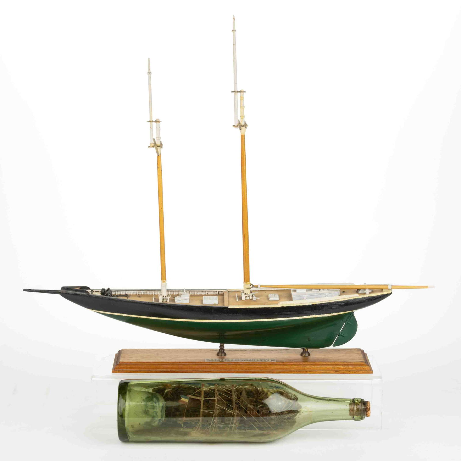 VINTAGE SHIP MODELS, LOT OF TWO: VINTAGE SHIP MODELS, LOT OF TWO, comprising a ship in a green wine bottle with a village in the background; and a wooden scale model of a fishing schooner labeled as the Gertrude L. Thebaud. Bottle fi