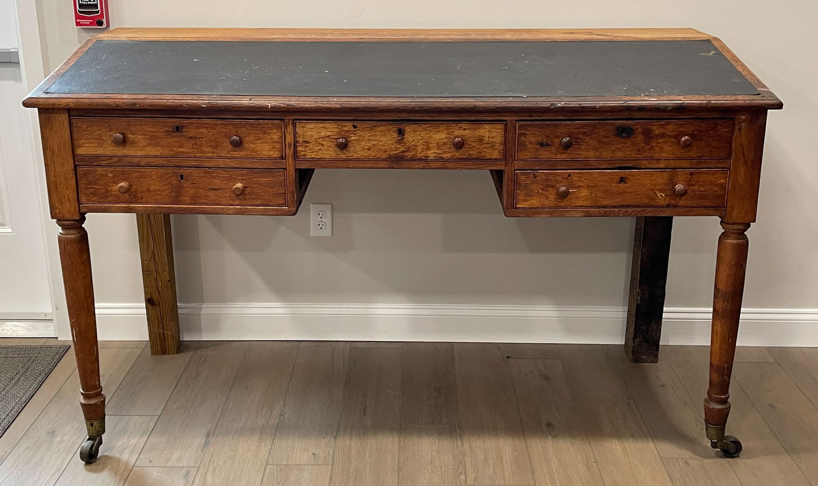 AMERICAN OAK STAND-UP MILL / STORE DESK: AMERICAN OAK STAND-UP MILL / STORE DESK, large form featuring slant-lid, five short drawers, and tall turned legs ending in brass casters. Oak, yellow pine, and poplar secondary woods. Old surface. Fo