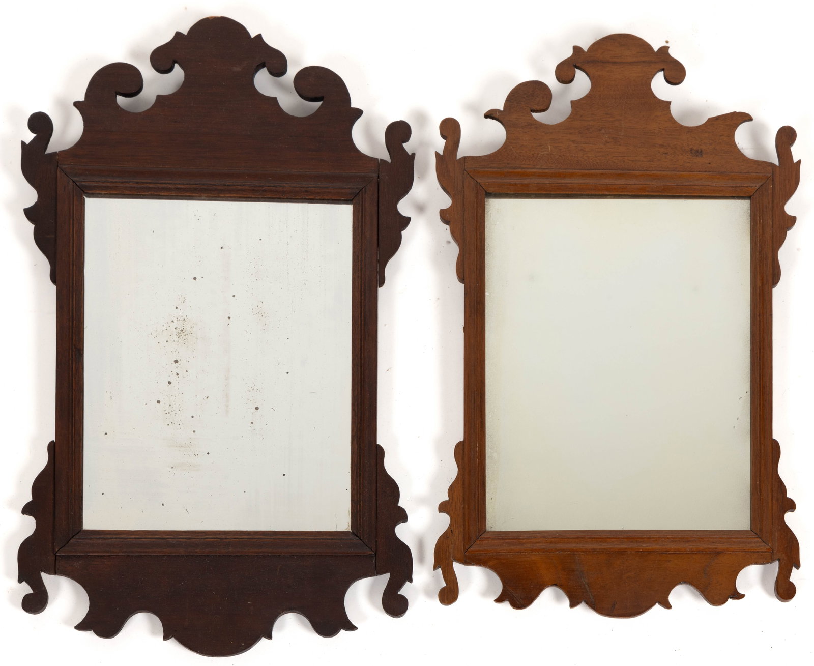 AMERICAN OR BRITISH CHIPPENDALE MAHOGANY LOOKING GLASS / WALL MIRRORS, LOT OF TWO: AMERICAN OR BRITISH CHIPPENDALE MAHOGANY LOOKING GLASS / WALL MIRRORS, LOT OF TWO, the cut-out scrolled work applied to a molded rectangular frame set with its possibly original mirror plate, and