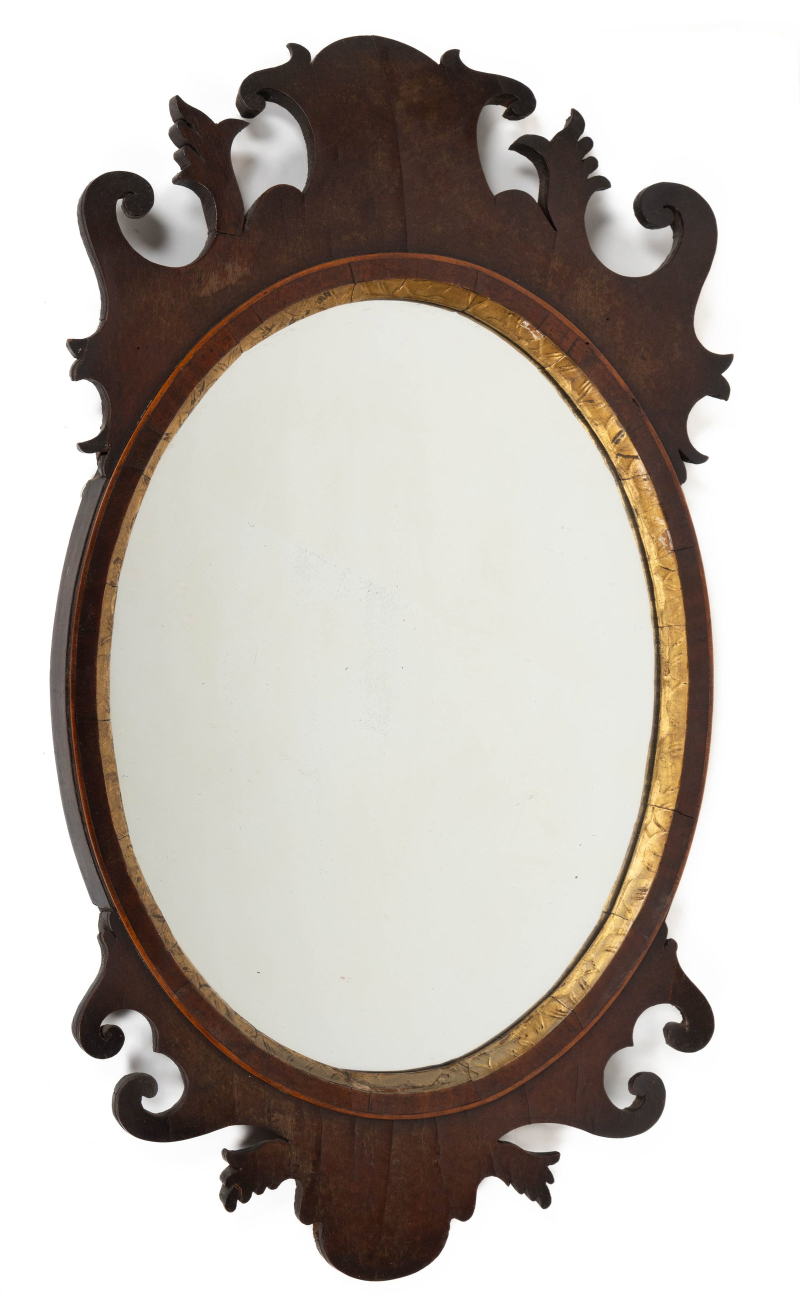 AMERICAN / ENGLISH CHIPPENDALE MAHOGANY OVAL LOOKING GLASS / WALL MIRROR: AMERICAN / ENGLISH CHIPPENDALE MAHOGANY OVAL LOOKING GLASS / WALL MIRROR, the cut-out scrolled work applied to an unusual oval veneered frame with a carved and gilded inner frame set with an