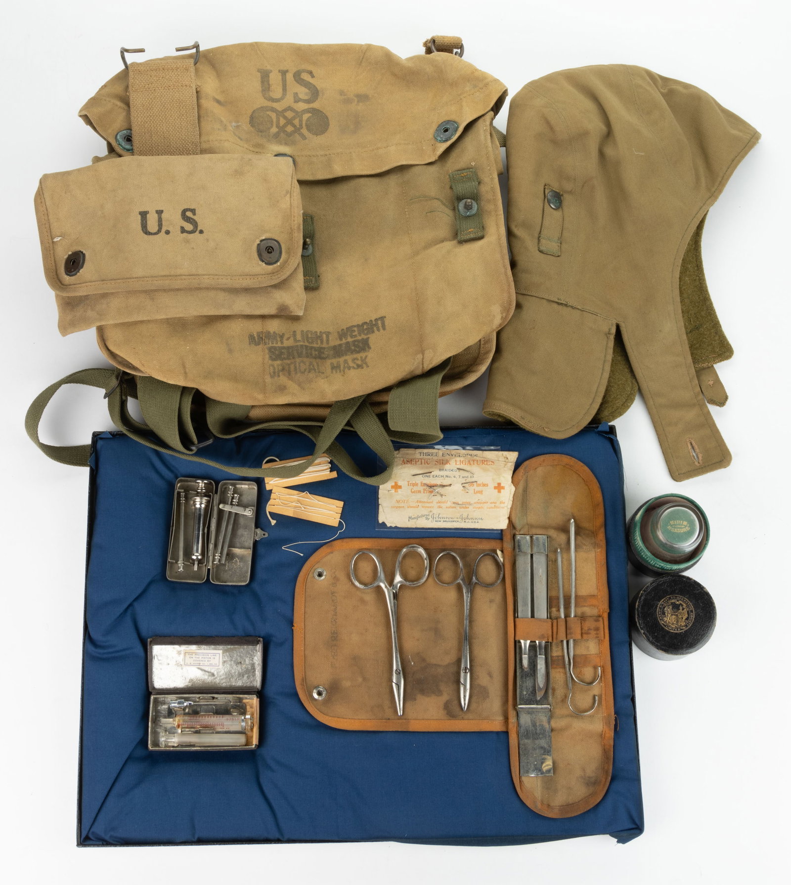 UNITED STATES MILITARY EQUIPMENT, LOT OF SIX: UNITED STATES MILITARY EQUIPMENT, LOT OF SIX, including a pocket surgical kit; an Army & Navy Co-Operative Society case with non-original glass; a 1918 WWI canvas haversack marked "E &am