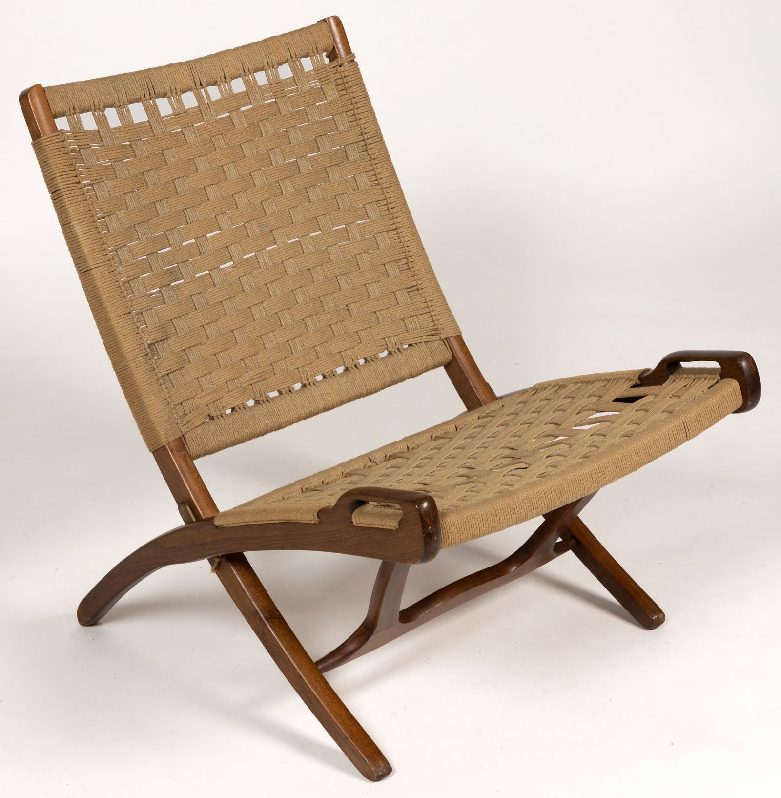 HANS WEGNER-STYLE MID-CENTURY MODERN WOVEN-SEAT FOLDING-CHAIR: HANS WEGNER-STYLE MID-CENTURY MODERN WOVEN-SEAT FOLDING-CHAIR, back and sides woven with a jute-like material, the legs splay and a sliding support acts as a stretcher. Mid 20th century. 29"