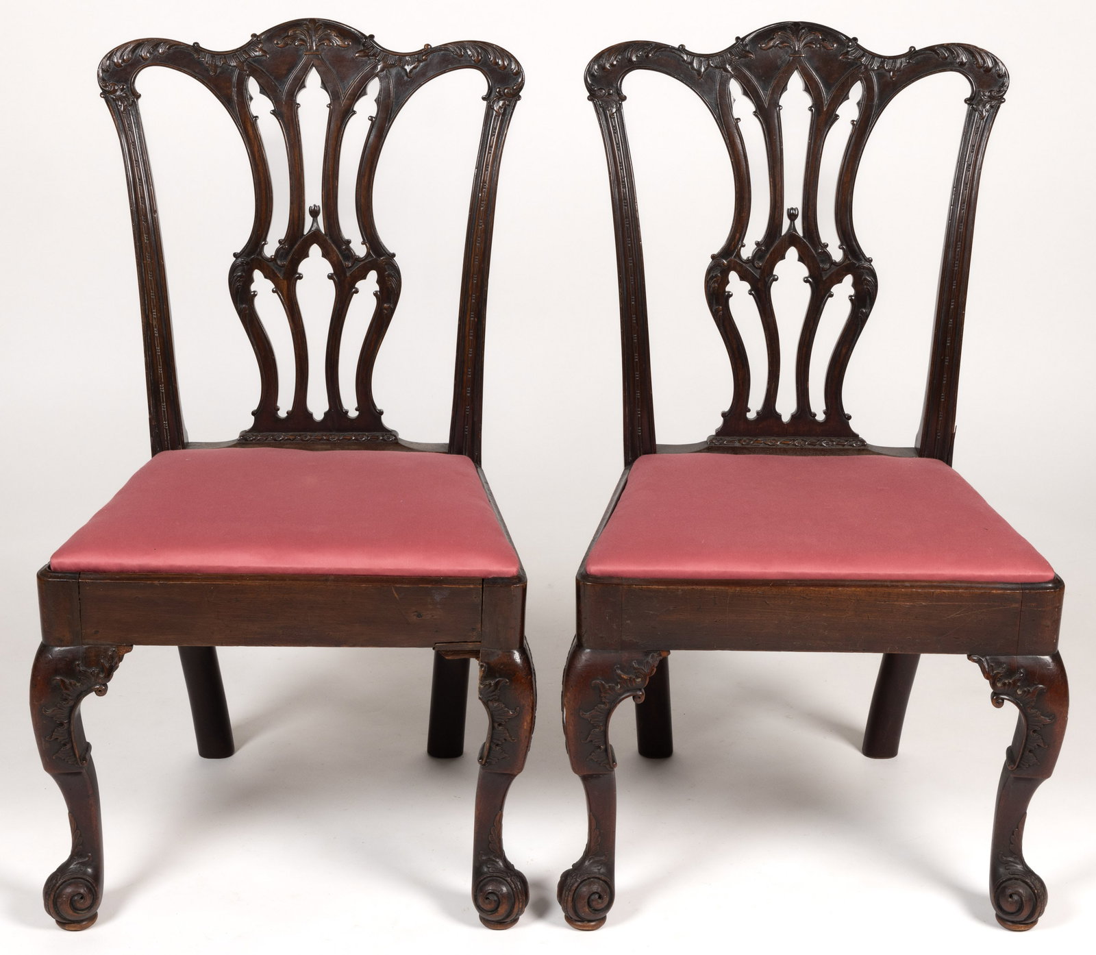 PAIR OF GEORGIAN MAHOGANY SIDE CHAIRS: PAIR OF GEORGIAN MAHOGANY SIDE CHAIRS, each featuring a foliate-carved crest rail over a pierced splat and trapezoidal seat frame, raised on cabriole legs terminating in scrolled feet. English. Late 1