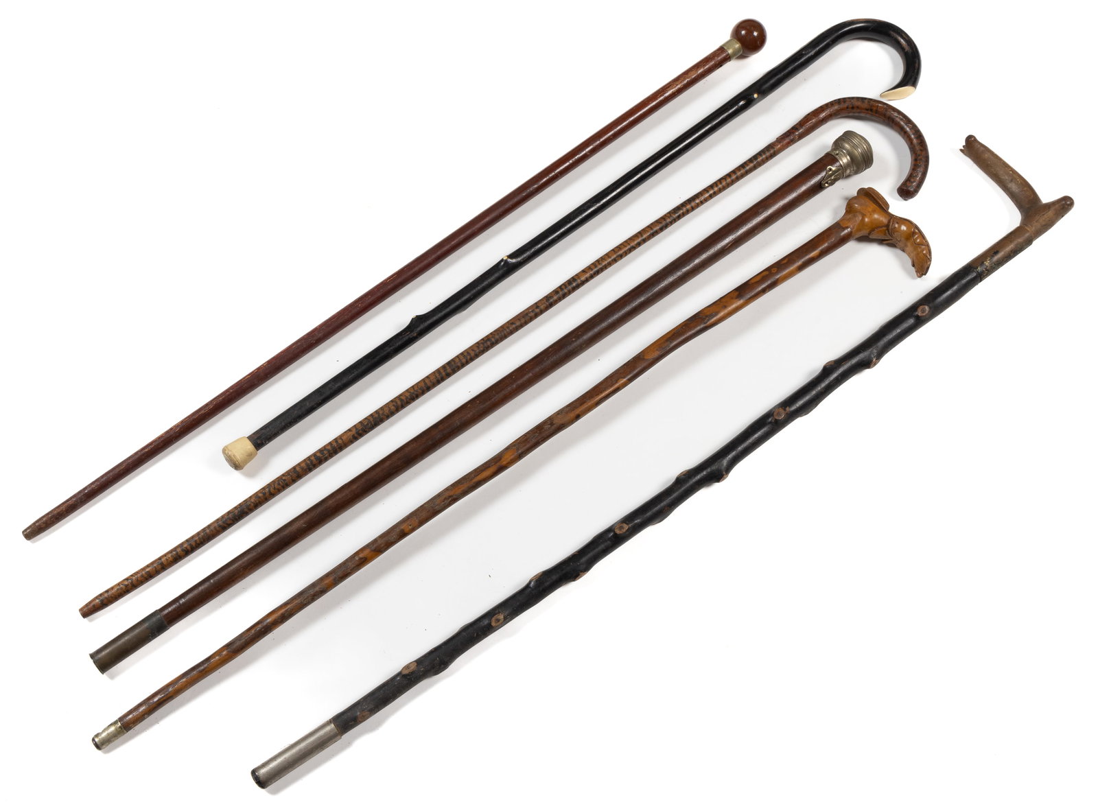 ASSORTED ANTIQUES CANES / WALKING STICKS, LOT OF SIX: ASSORTED ANTIQUES CANES / WALKING STICKS, LOT OF SIX, comprising an example depicting a ragged shoe with a foot coming through the holes; an example with bone tips inlaid into the knots and on the end