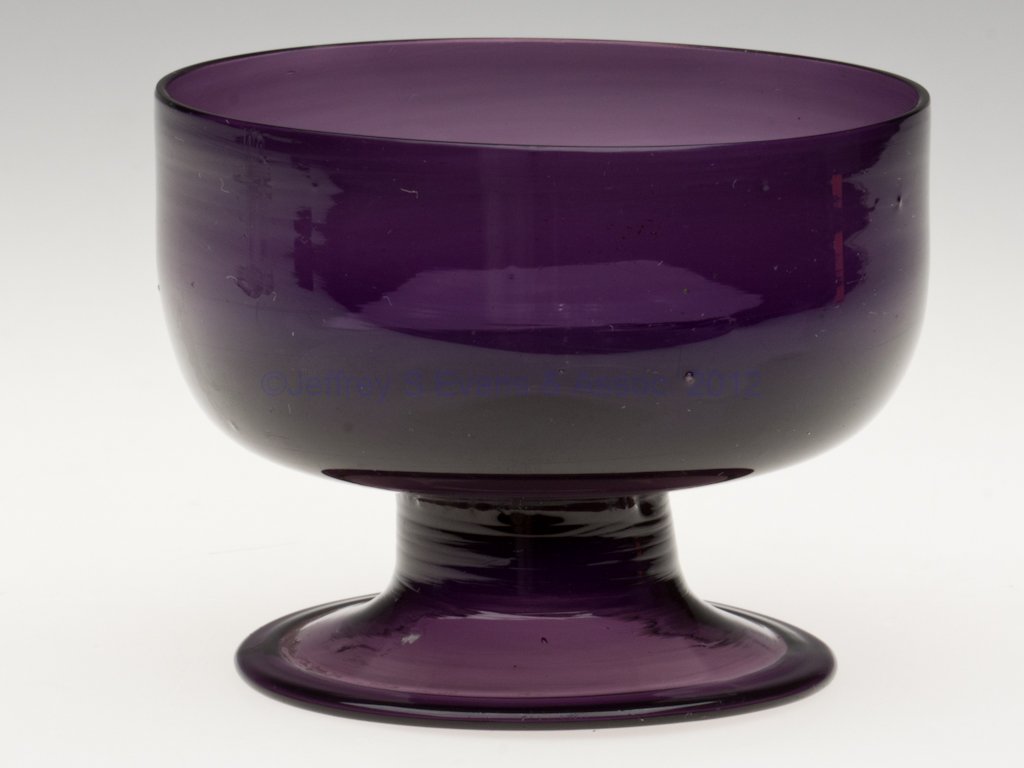 FREE-BLOWN SUGAR BOWL: FREE-BLOWN SUGAR BOWL, brilliant violet lead glass, short bucket-form bowl raised on an applied trumpet foot with folded rim and rough pontil mark. 1780-1820. 3 1/4" H, 4 1/4" D rim, 3 3/8" D foot.