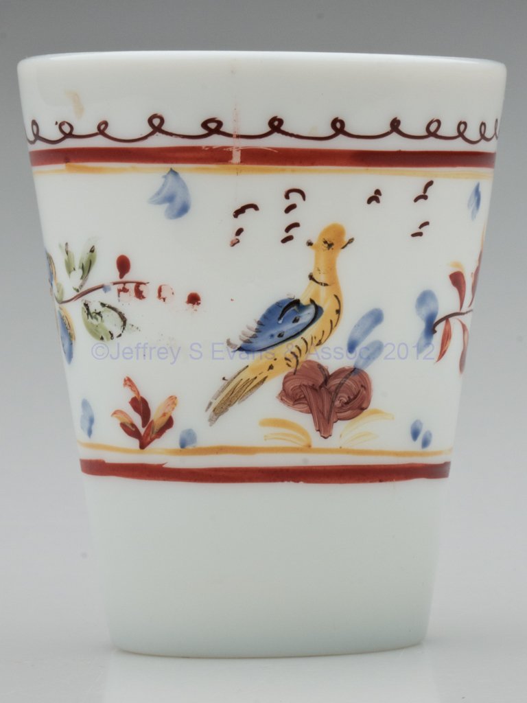 FREE-BLOWN AND DECORATED TAPER TUMBLER: FREE-BLOWN AND DECORATED TAPER TUMBLER, fiery opalescent, polychrome enamel decoration featuring a bird perched on a heart flanked by floral sprays, rough pontil mark. Late 18th/early 19th century. 3 