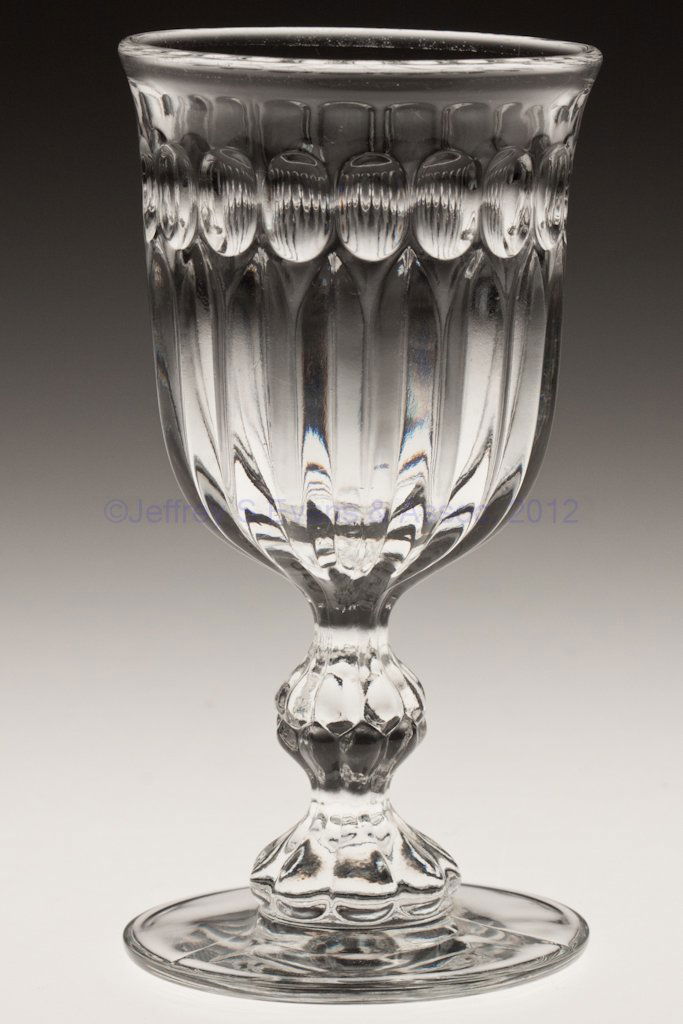 GIANT PRISM WITH THUMBPRINT BAND CHAMPAGNE GLASS: GIANT PRISM WITH THUMBPRINT BAND CHAMPAGNE GLASS, colorless lead glass. Third quarter 19th century. 5 1/8" H.Provenance: Collection of Walter "Bud" Marchant.