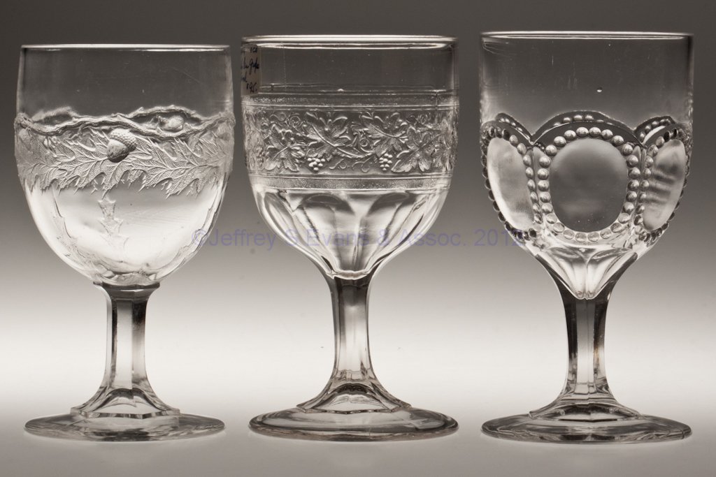 VARIOUS EAPG GOBLETS, LOT OF THREE: VARIOUS EAPG GOBLETS, LOT OF THREE, colorless lead glass, comprising an Early Paneled Grape Band, a Paneled Acorn Band and a Beaded Circle. Third quarter 19th century. 5 7/8" to 6 1/8" H. Provenance: 