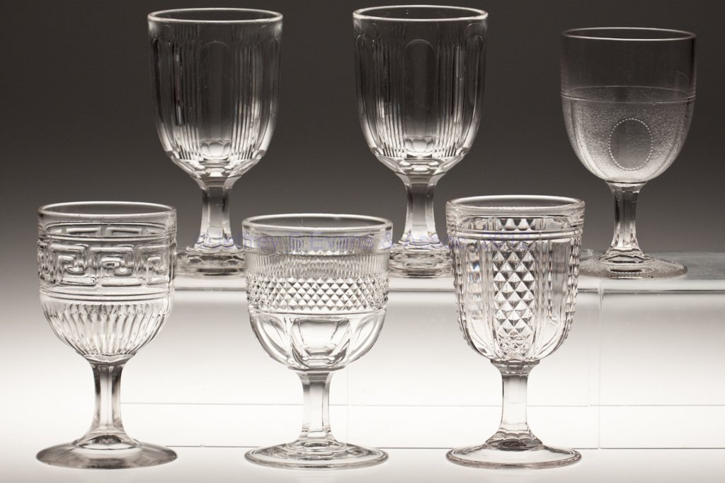 VARIOUS EAPG GOBLETS, LOT OF SIX: VARIOUS EAPG GOBLETS, LOT OF SIX, colorless lead glass, including two Paneled Finetooth and a clear Roman Key. Third quarter 19th century. 5 3/8" to 6 1/8" H. Provenance: Lillian "Lil" and Walter "Bud