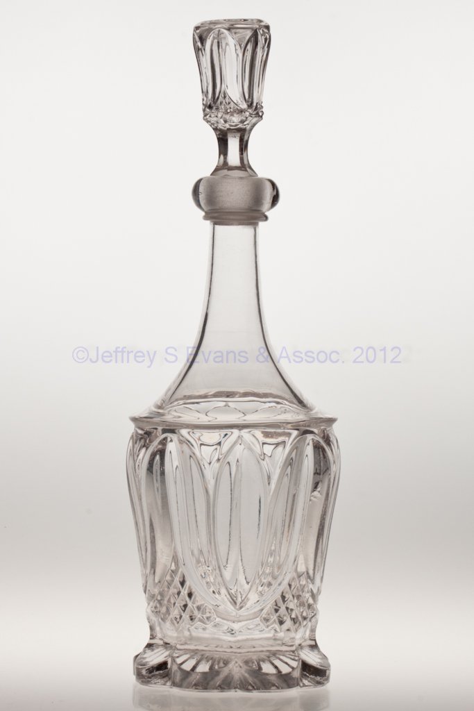 TULIP WITH SAWTOOTH QUART DECANTER: TULIP WITH SAWTOOTH QUART DECANTER, colorless lead glass, applied lip, original stopper, polished pontil mark to base and to top of stopper. Third quarter 19th century. 14 1/4" HOA, 11" H bottle. Prov