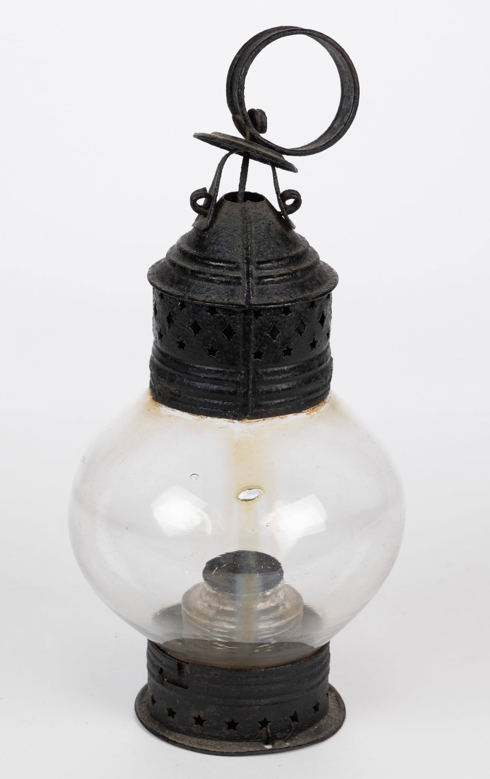 SHEET-IRON PIERCED AND PUNCHED ONION LANTERN: SHEET-IRON PIERCED AND PUNCHED ONION LANTERN, colorless fixed globe, brass cap with diamond and stars pattern, strap ring handle, later worn black paint, removable star-pierced base with bayonet mecha