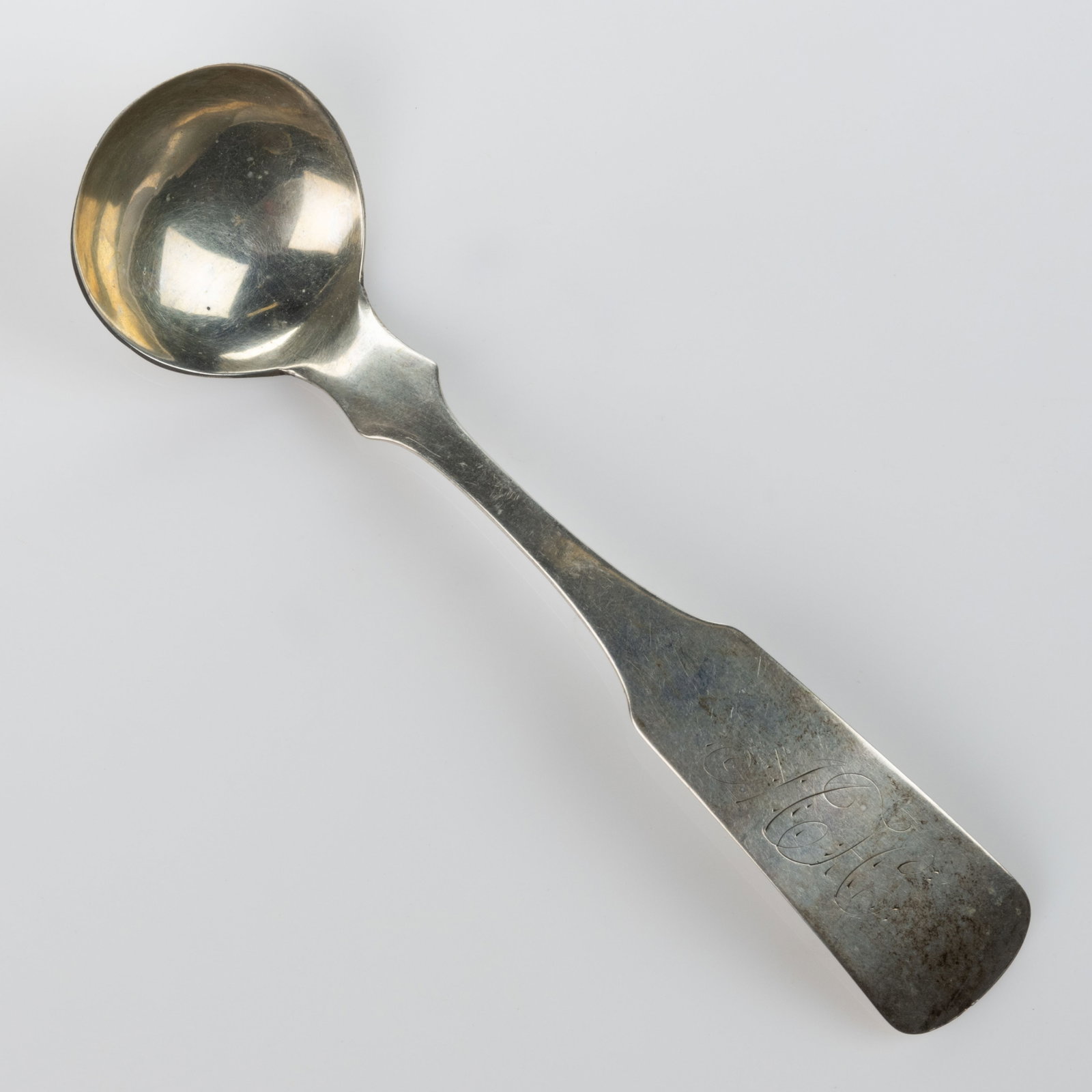 OLIVER C. STEELE, RICHMOND, KENTUCKY COIN SILVER SAUCE LADLE: OLIVER C. STEELE, RICHMOND, KENTUCKY COIN SILVER SAUCE LADLE, a round bowl on a wide fiddle handle with pointed shoulders and engraved "MH" initials. Impressed to back with partially worn &q