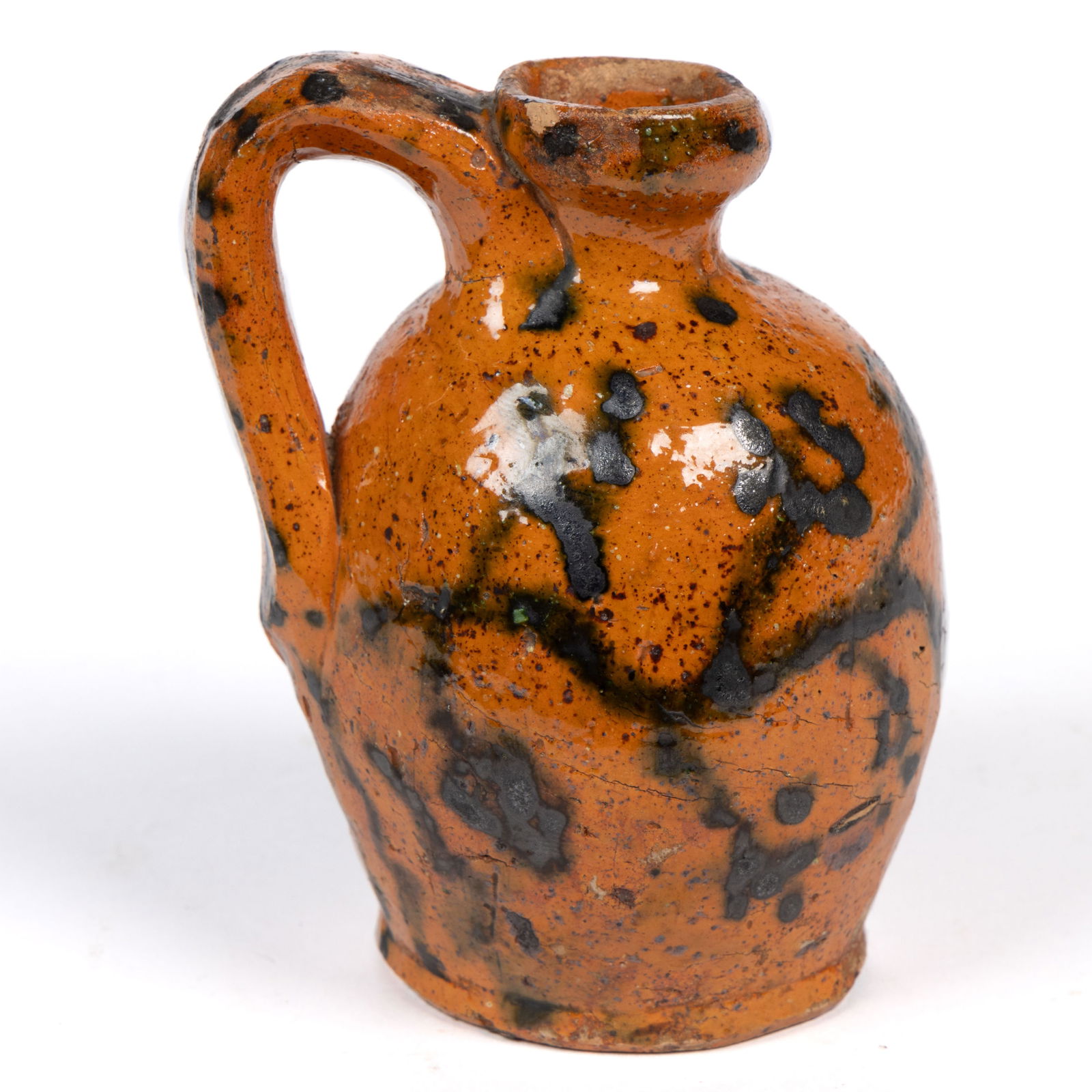 VALLEY OF VIRGINIA / EASTERN TENNESSEE DECORATED EARTHENWARE / REDWARE MINIATURE JUG: VALLEY OF VIRGINIA / EASTERN TENNESSEE DECORATED EARTHENWARE / REDWARE MINIATURE JUG, lead-glazed, ovoid form with plain mouth and applied strap handle. Slip-trailed manganese horizontal double-bloom