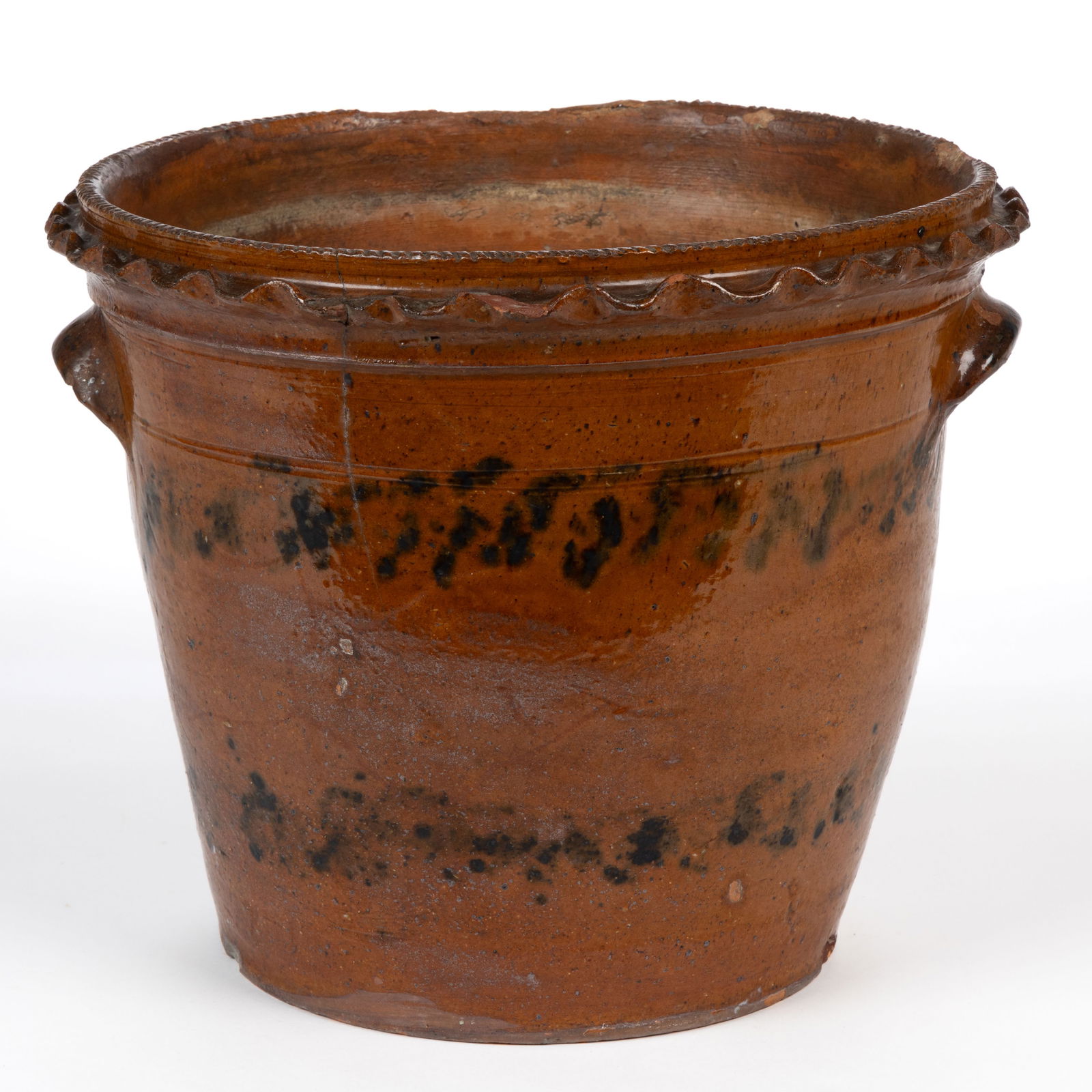 PENNSYLVANIA EARTHENWARE / REDWARE LARGE FLOWER POT: PENNSYLVANIA EARTHENWARE / REDWARE LARGE FLOWER POT, lead-glazed with manganese splotches, conical form with coggled rim and ruffled decoration below, applied arched tab handles, and punched drain hol