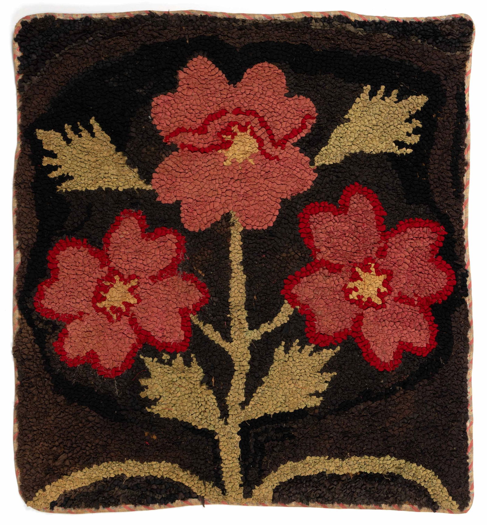 AMERICAN FOLK ART FLORAL HOOKED RUG: AMERICAN FOLK ART FLORAL HOOKED RUG, square form, depicting three large pink flower blooms with a green stem and leaves on a dark-colored background, all four edges with applied print fabric bind