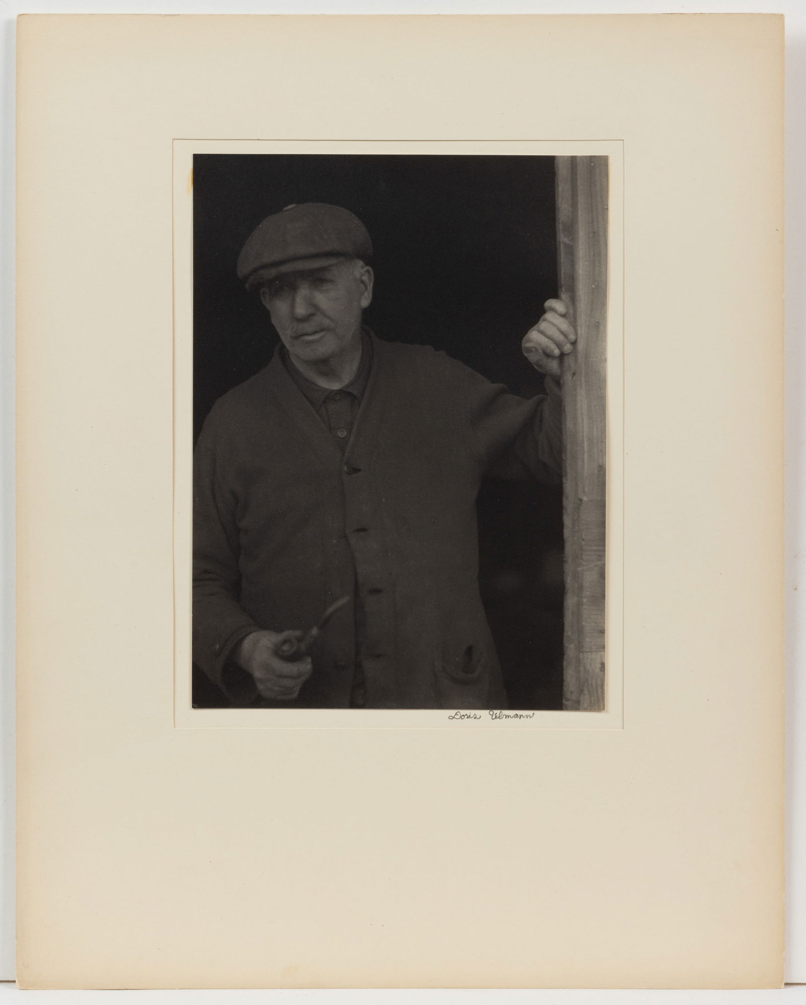 DORIS ULMANN (AMERICAN, 1882-1934) "NEW ENGLAND MAN" PHOTOGRAPHIC PORTRAIT: DORIS ULMANN (AMERICAN, 1882-1934) "NEW ENGLAND MAN" PHOTOGRAPHIC PORTRAIT, platinum print depicting a standing man wearing all dark clothing and holding a pipe in right hand, pencil si