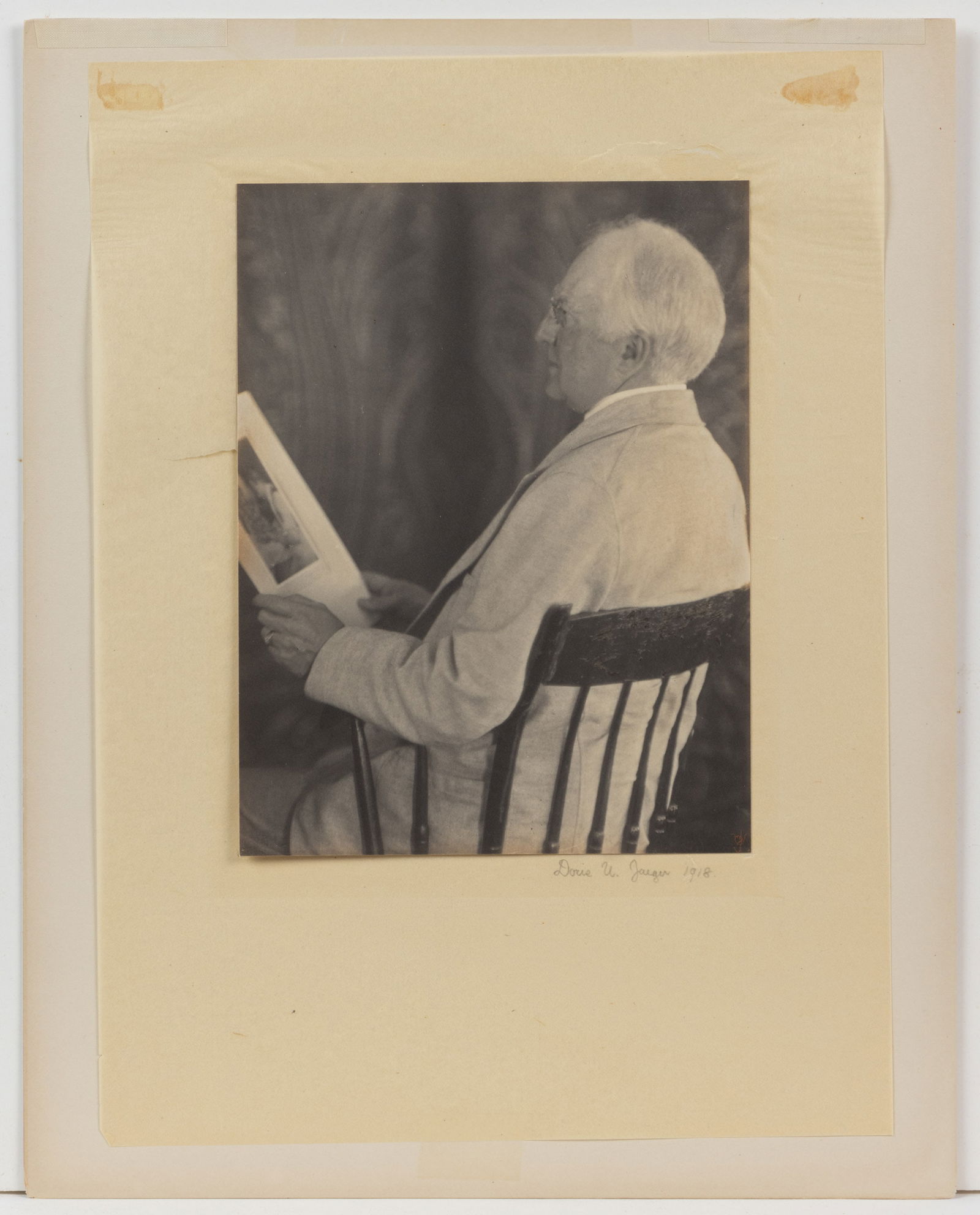 DORIS ULMANN JAEGER (AMERICAN, 1882-1934) MAN HOLDING ULMANN PORTRAIT PHOTOGRAPHIC PORTRAIT: DORIS ULMANN JAEGER (AMERICAN, 1882-1934) MAN HOLDING ULMANN PORTRAIT PHOTOGRAPHIC PORTRAIT, platinum print on tissue paper depicting a sitting gentleman gazing at one of Ulmann's portrait photogr